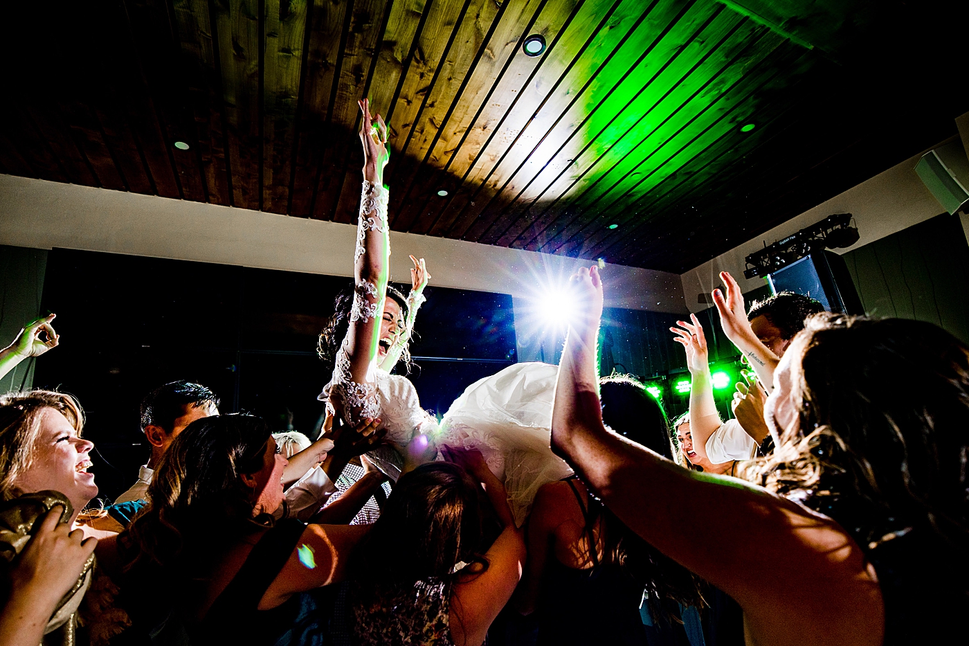 Bride being tossed in air by guests at wedding reception | McArthur Weddings and Events