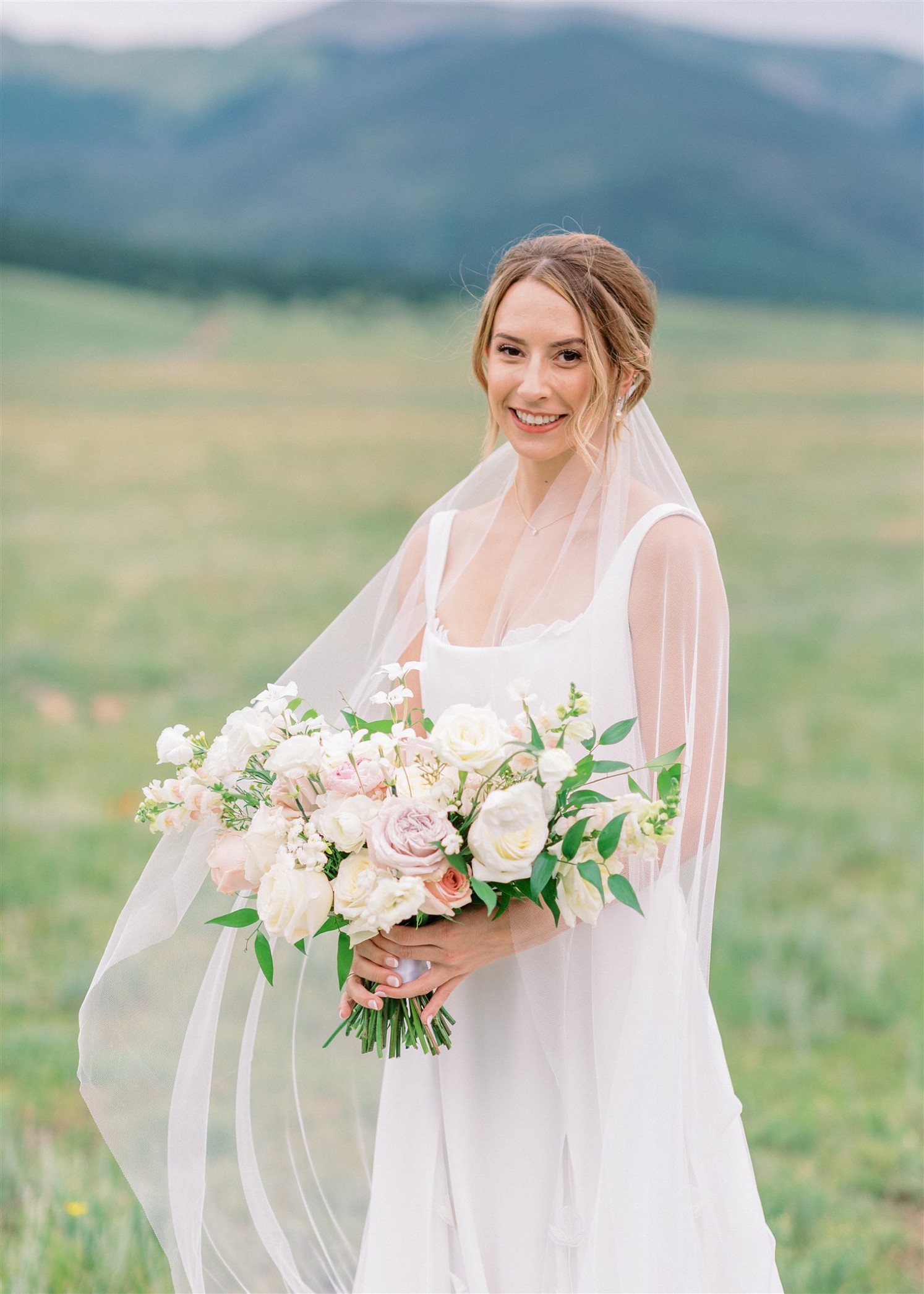 Bride standing in field at Three Peaks Ranch | McArthur Weddings and Events
