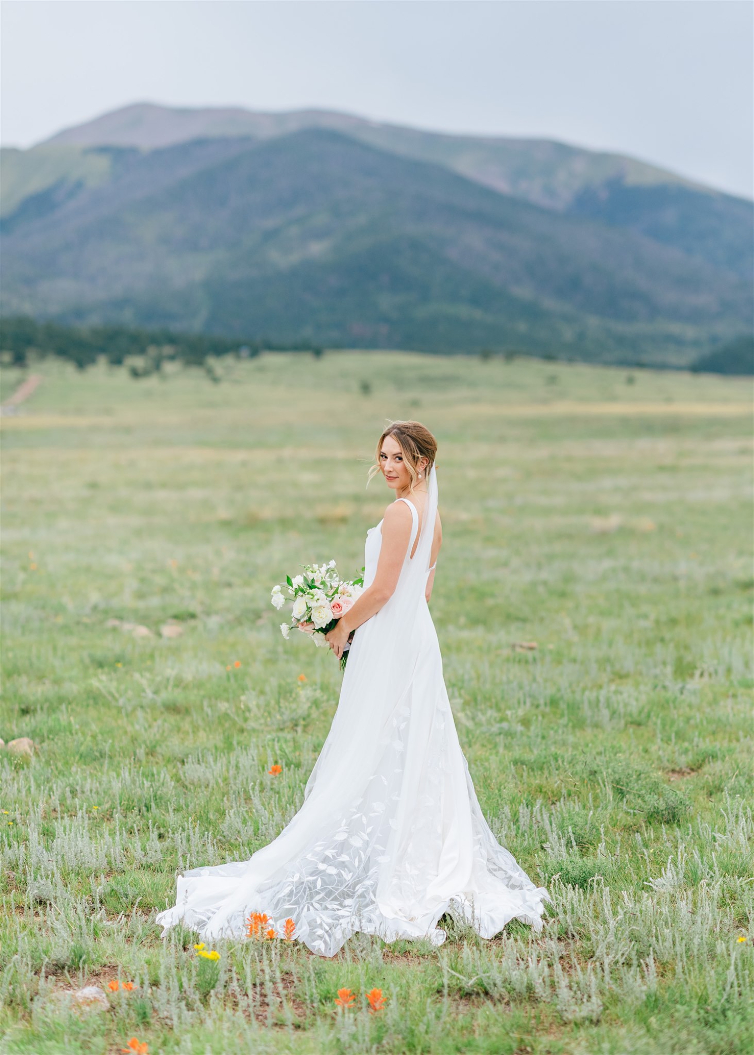 Bride looking over shoulder at Colorado destination wedding | McArthur Weddings and Events
