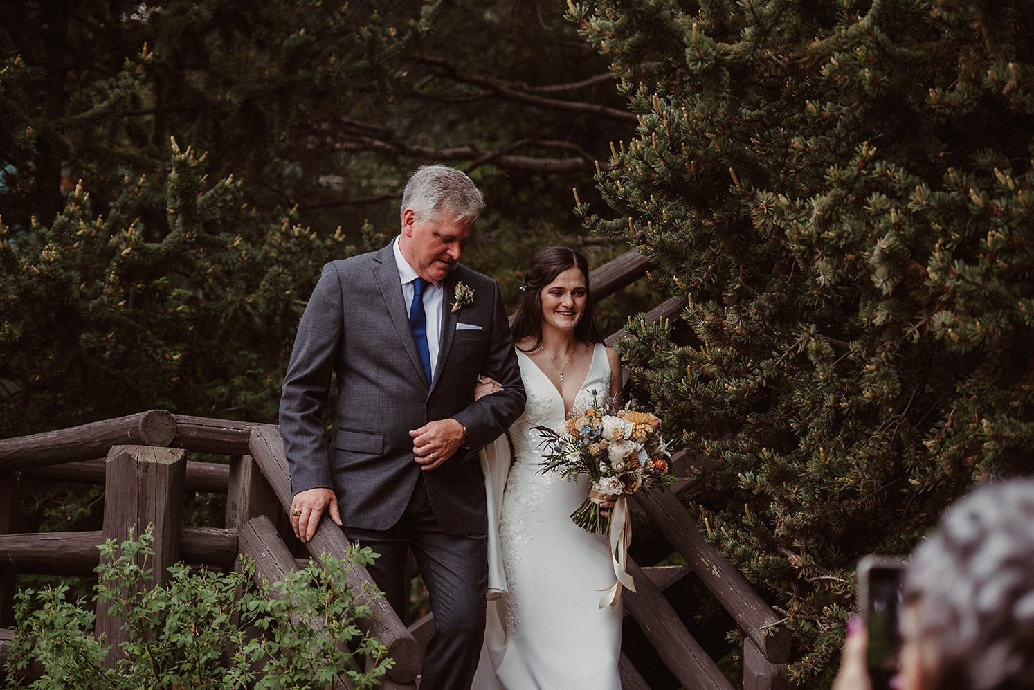 Walking down steps to ceremony space with father at Colorado Airbnb Wedding | McArthur Weddings and Events