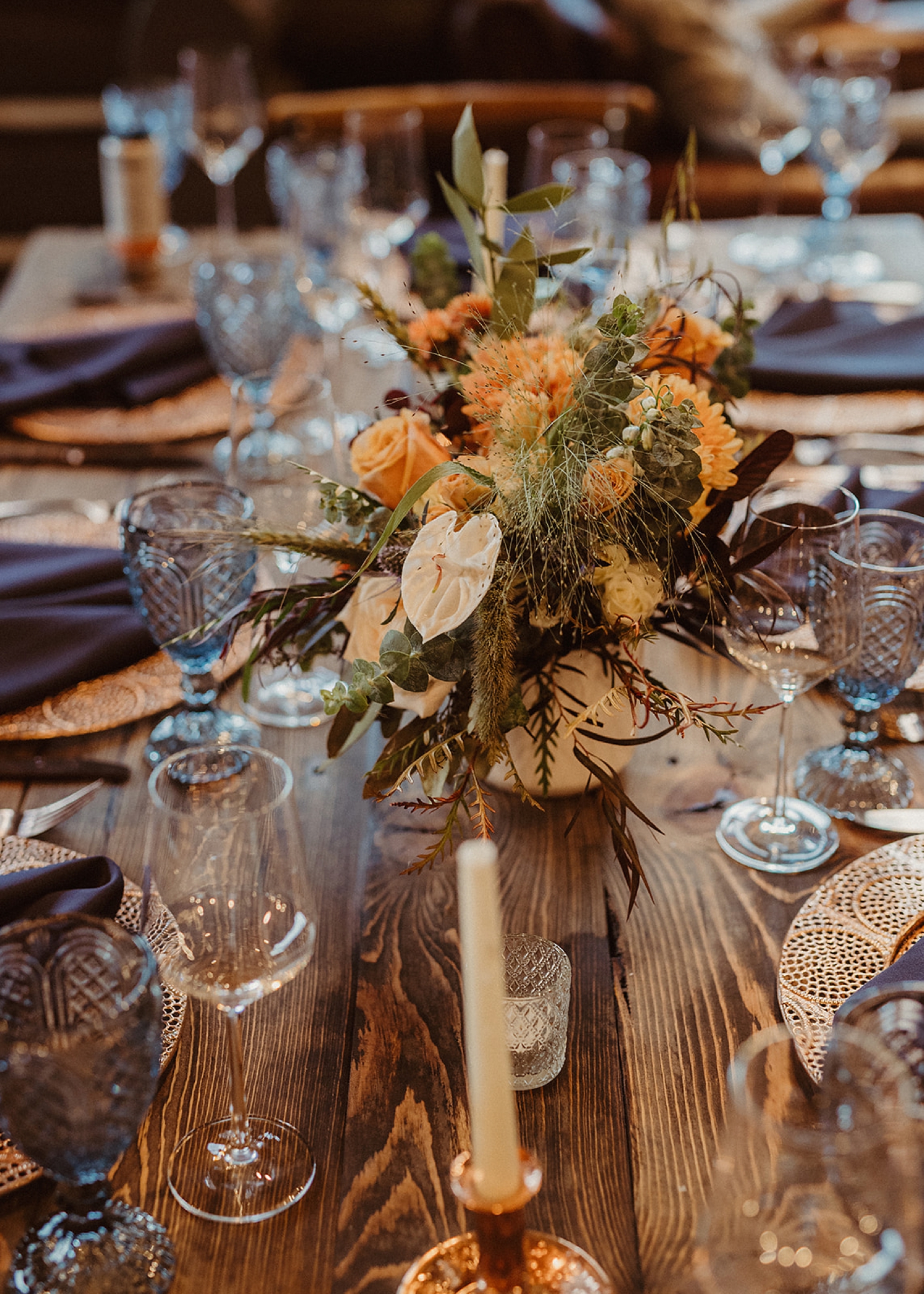 Muted yellow and orange floral centerpieces at Colorado Airbnb wedding reception | McArthur Weddings and Events
