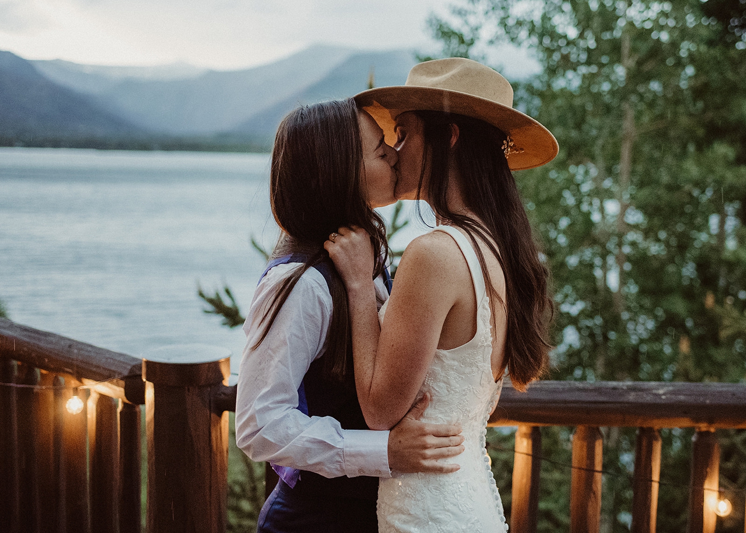 Partners kissing after dancing in rain at Colorado Airbnb wedding | McArthur Weddings and Events
