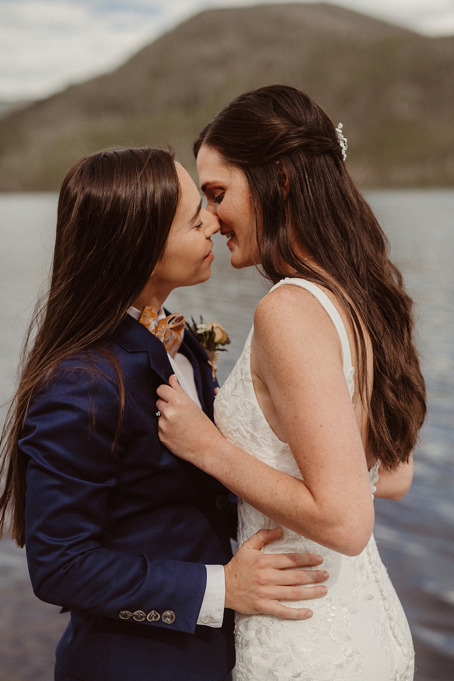 Couple kissing in front of lake at Colorado Airbnb wedding | McArthur Weddings and Events
