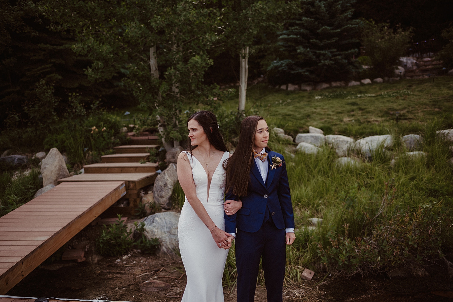 Couple holding hands and looking away from each other at Colorado Airbnb wedding | McArthur Weddings and Events