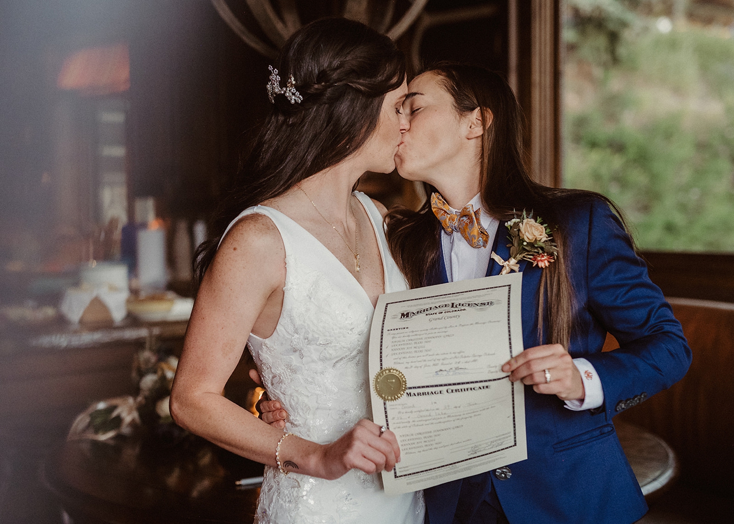 Couple kissing and holding marriage license after wedding ceremony at Colorado Airbnb wedding | McArthur Weddings and Events