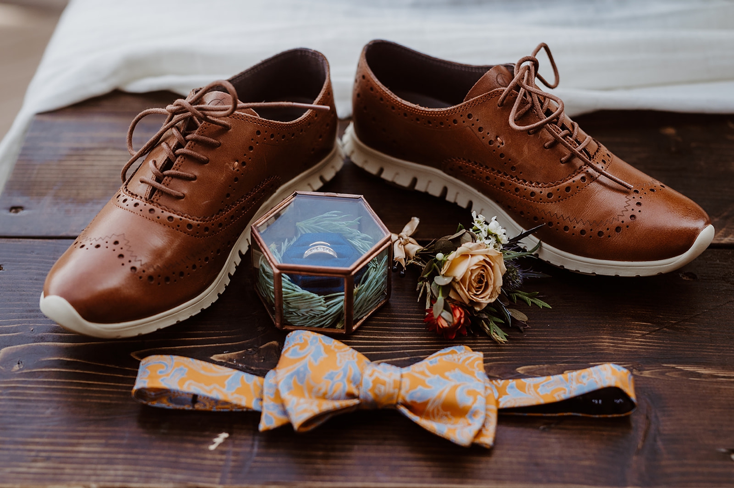 Brown shoes, wedding rings, boutonnière, and bowtie | McArthur Weddings and Events