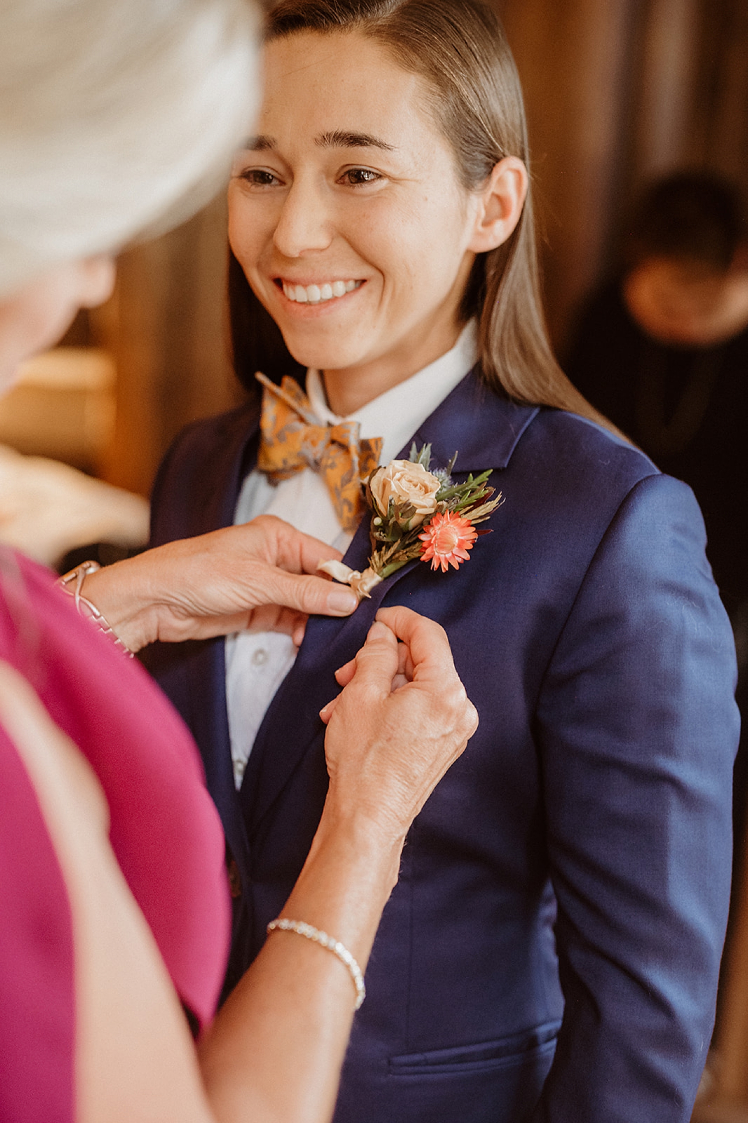 Mom helping put boutonniere on before Colorado Airbnb wedding | McArthur Weddings and Events