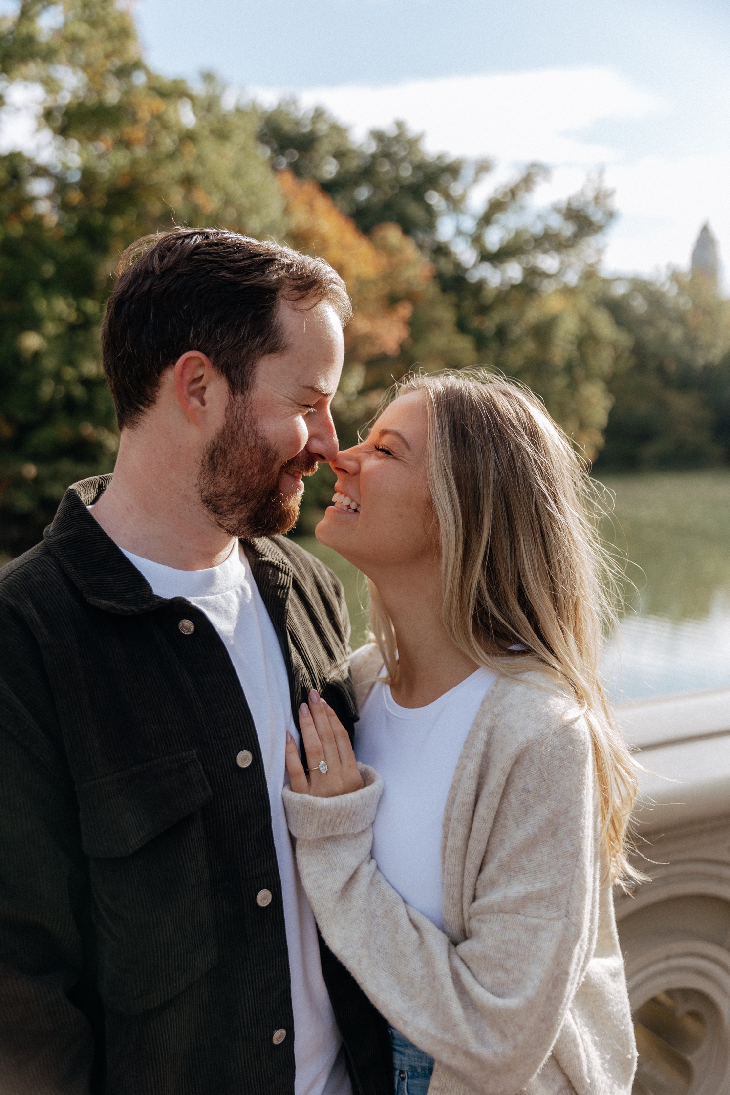 Newly engaged couple looking at each other while standing on bridge during engagement shoot | McArthur Weddings and Events