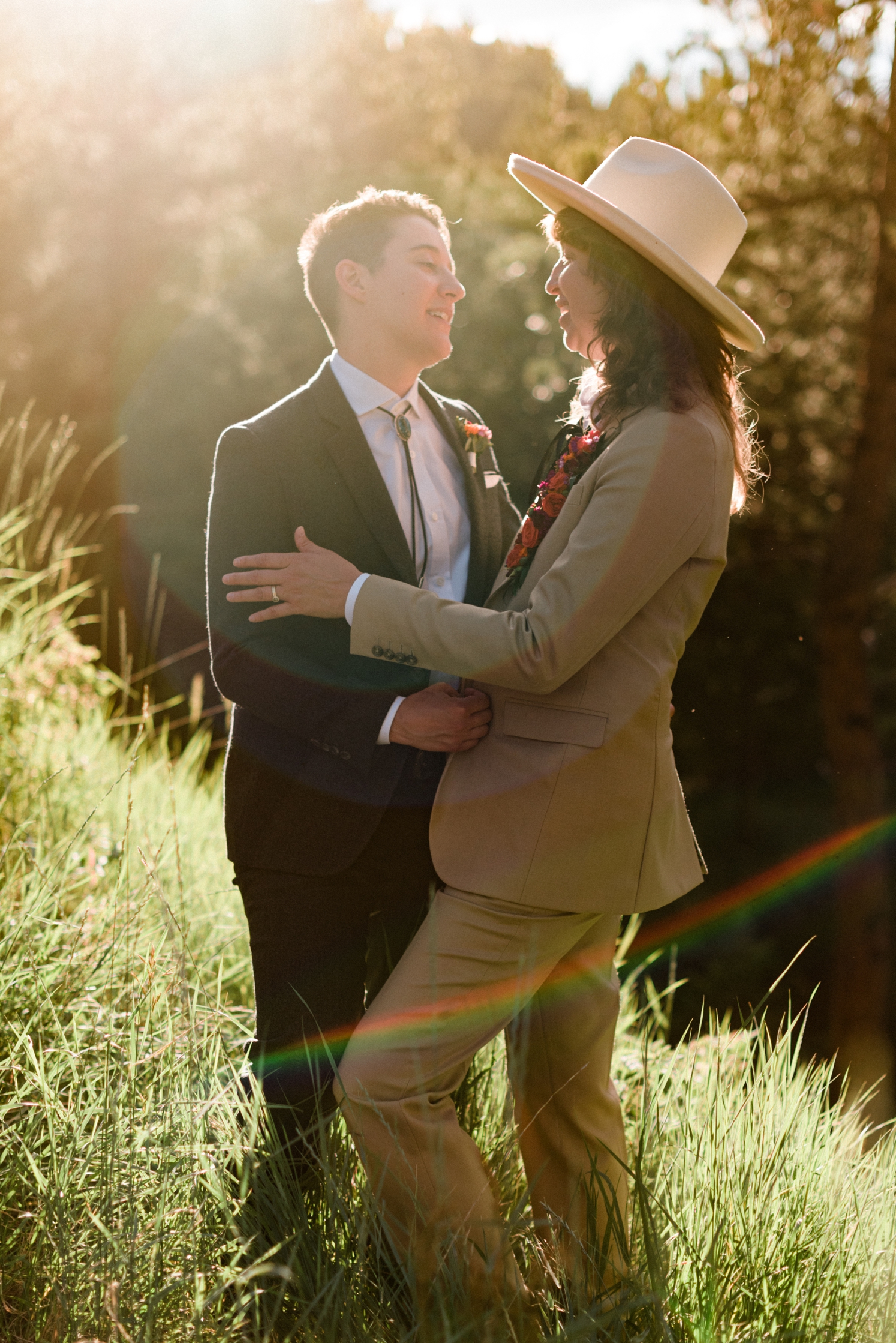 Couple standing in field at sunset and looking at each other | McArthur Weddings and Events