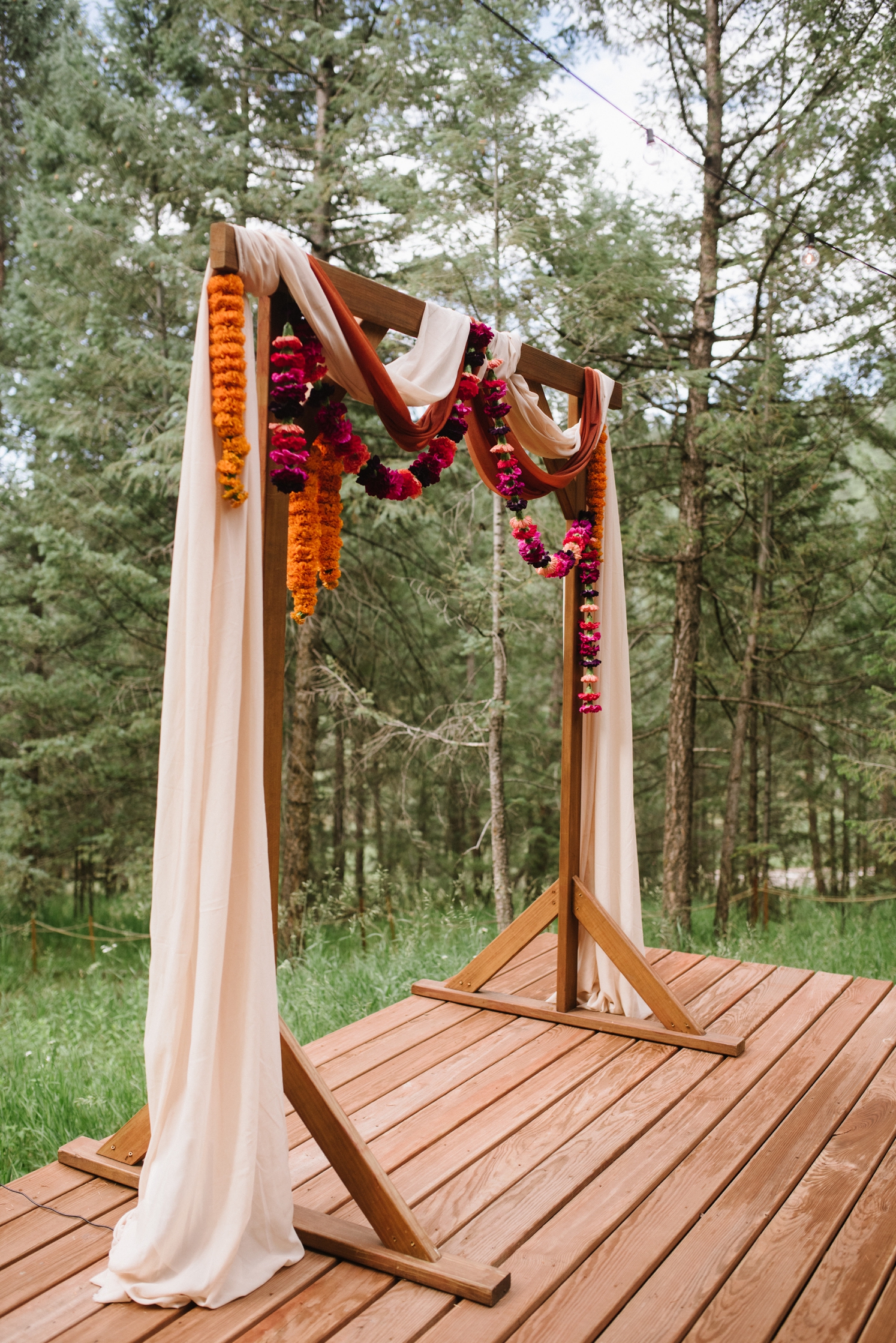 Ceremony arch draped with fabric and floral garlands at LGBTQ wedding | McArthur Weddings and Events