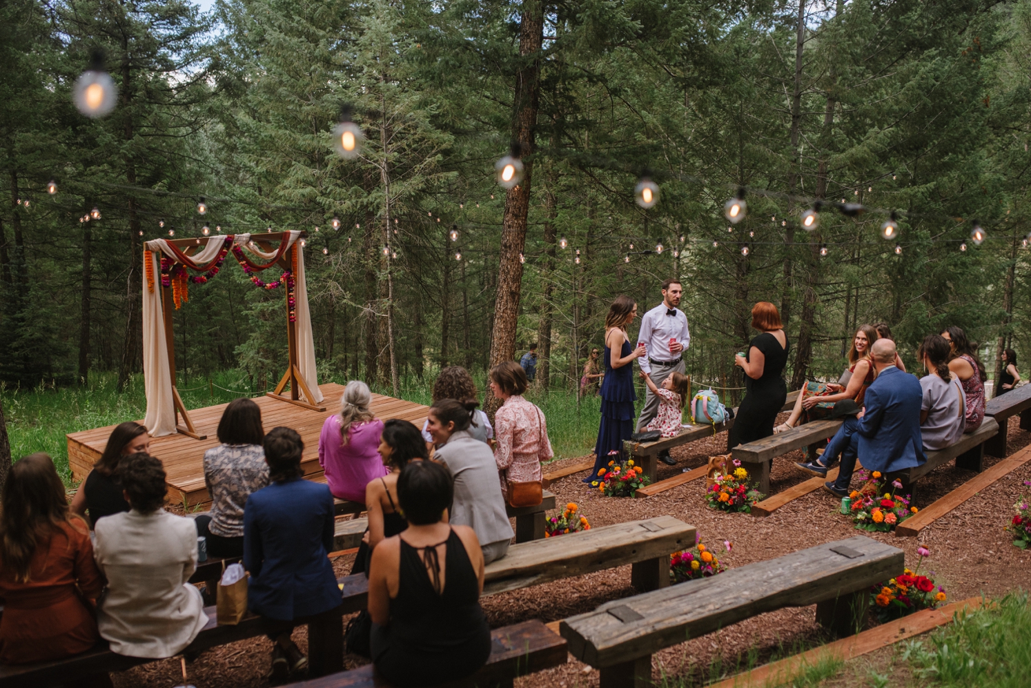 Guests sitting on benches at intimate wedding ceremony at Juniper Mountain House | McArthur Weddings and Events