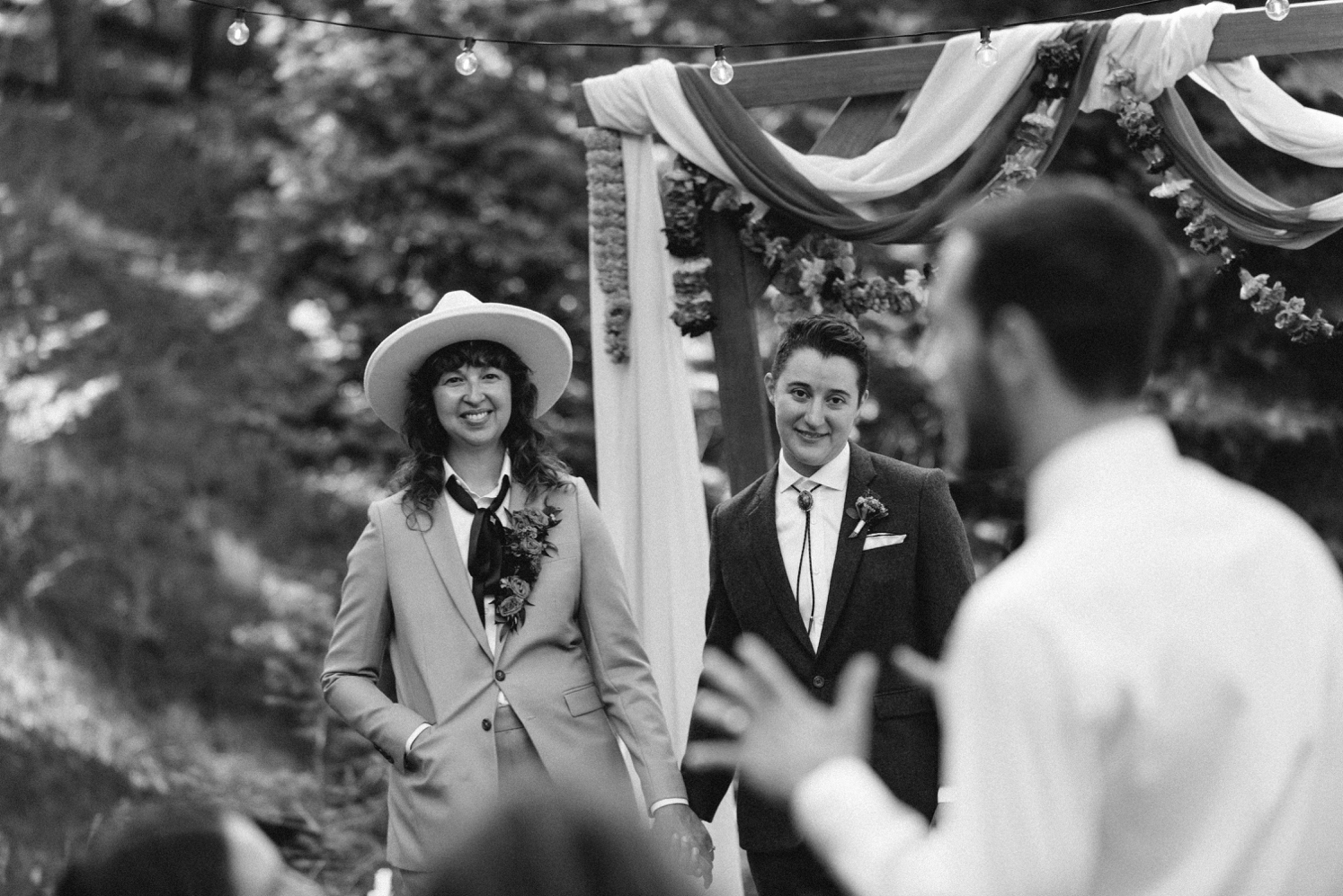 Couple looking at guest speaking to them during wedding ceremony | McArthur Weddings and Events