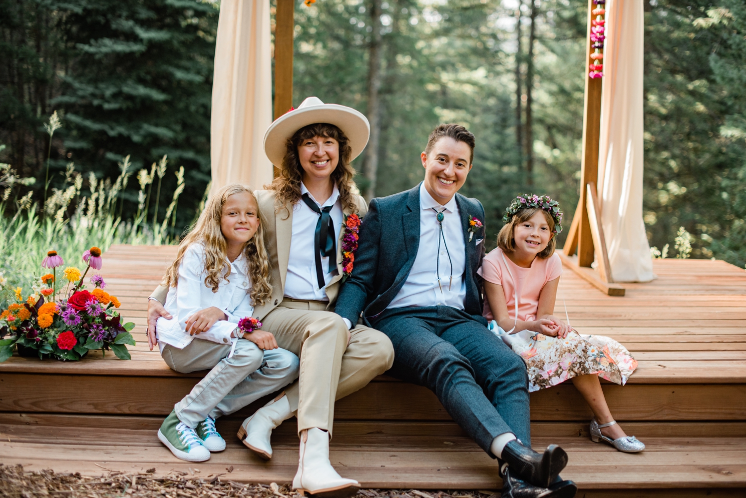 Couple sitting with daughters after LGBTQ wedding ceremony | McArthur Weddings and Events