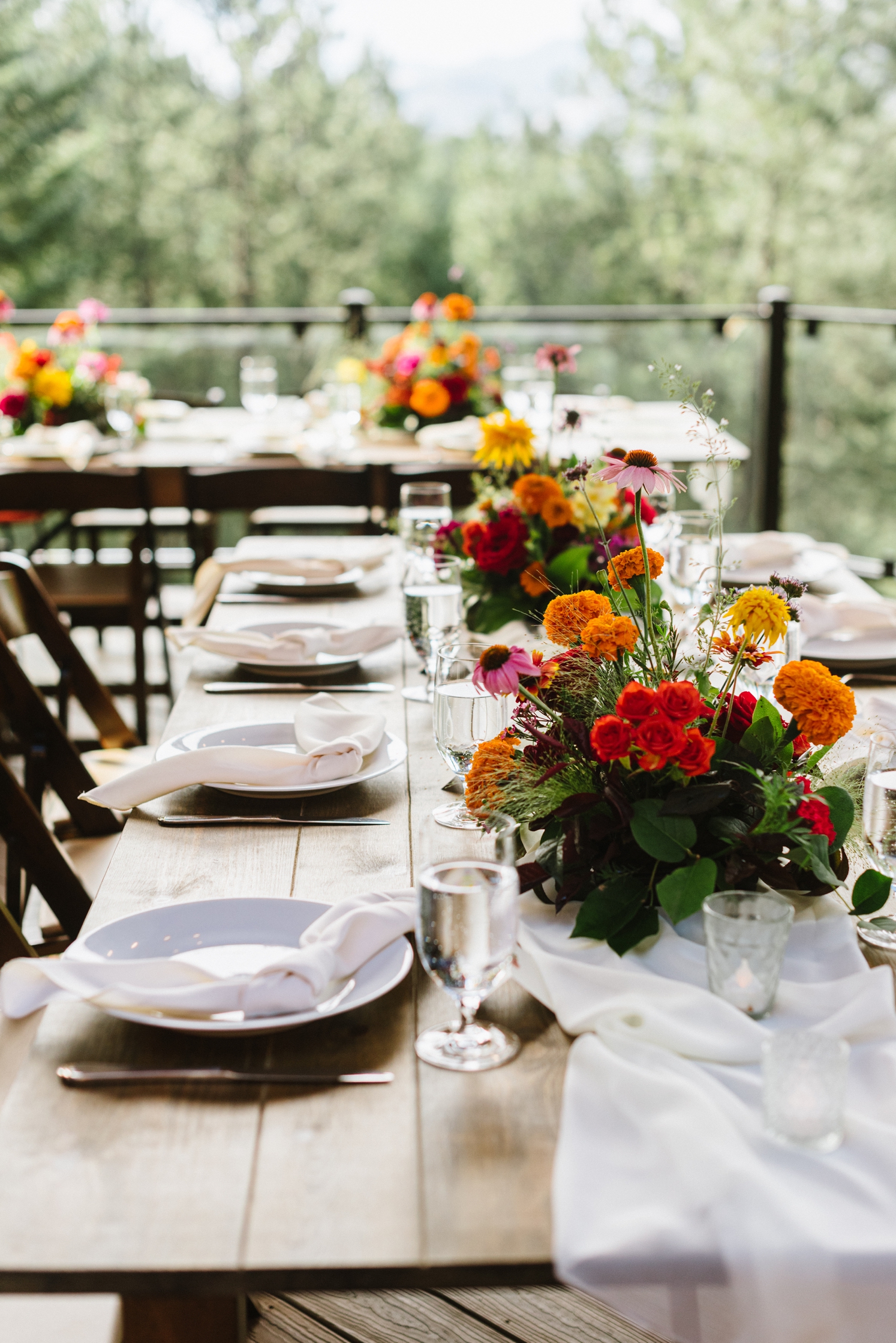 Bright, colorful floral arrangements at wedding reception at Juniper Mountain House | McArthur Weddings and Events