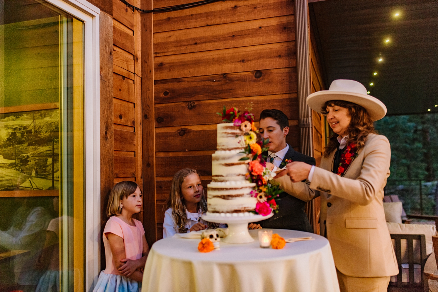 Couple cutting cake with their daughters | McArthur Weddings and Events