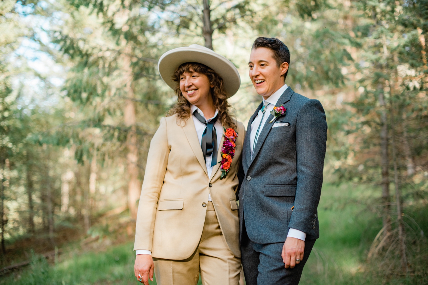 Full service wedding planner: Couple wearing suits standing in forest in Colorado at wedding | McArthur Weddings and Events