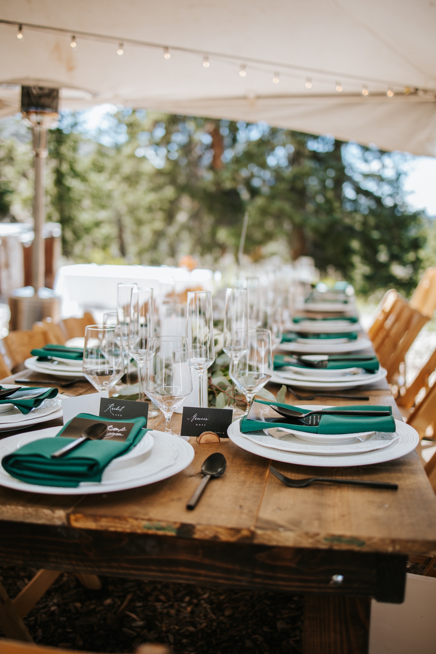 Green napkins with black flatware, white candles, and greenery at wedding reception | McArthur Weddings and Events
