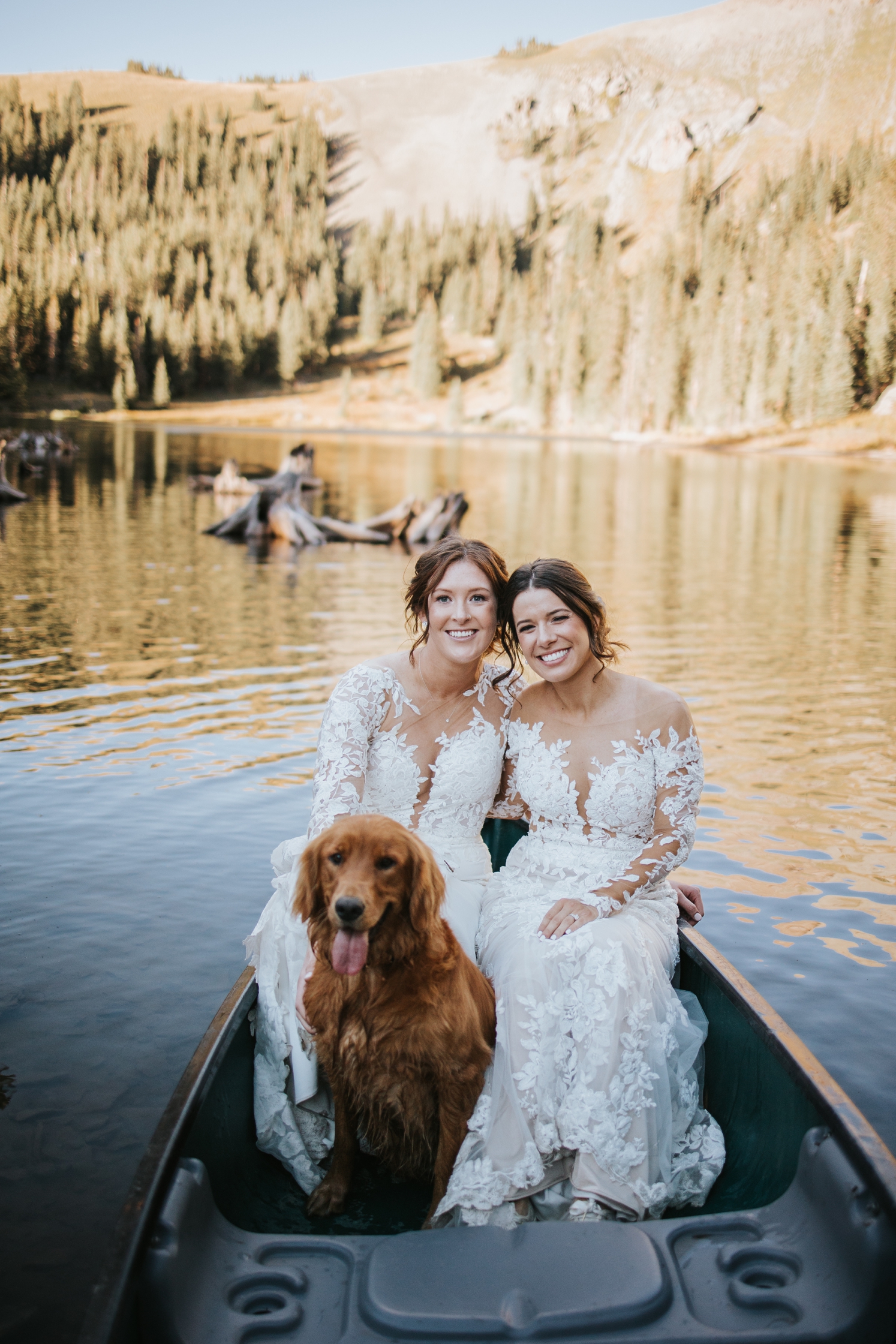 Partners sitting in canoe with dog at Telluride wedding | McArthur Weddings and Events