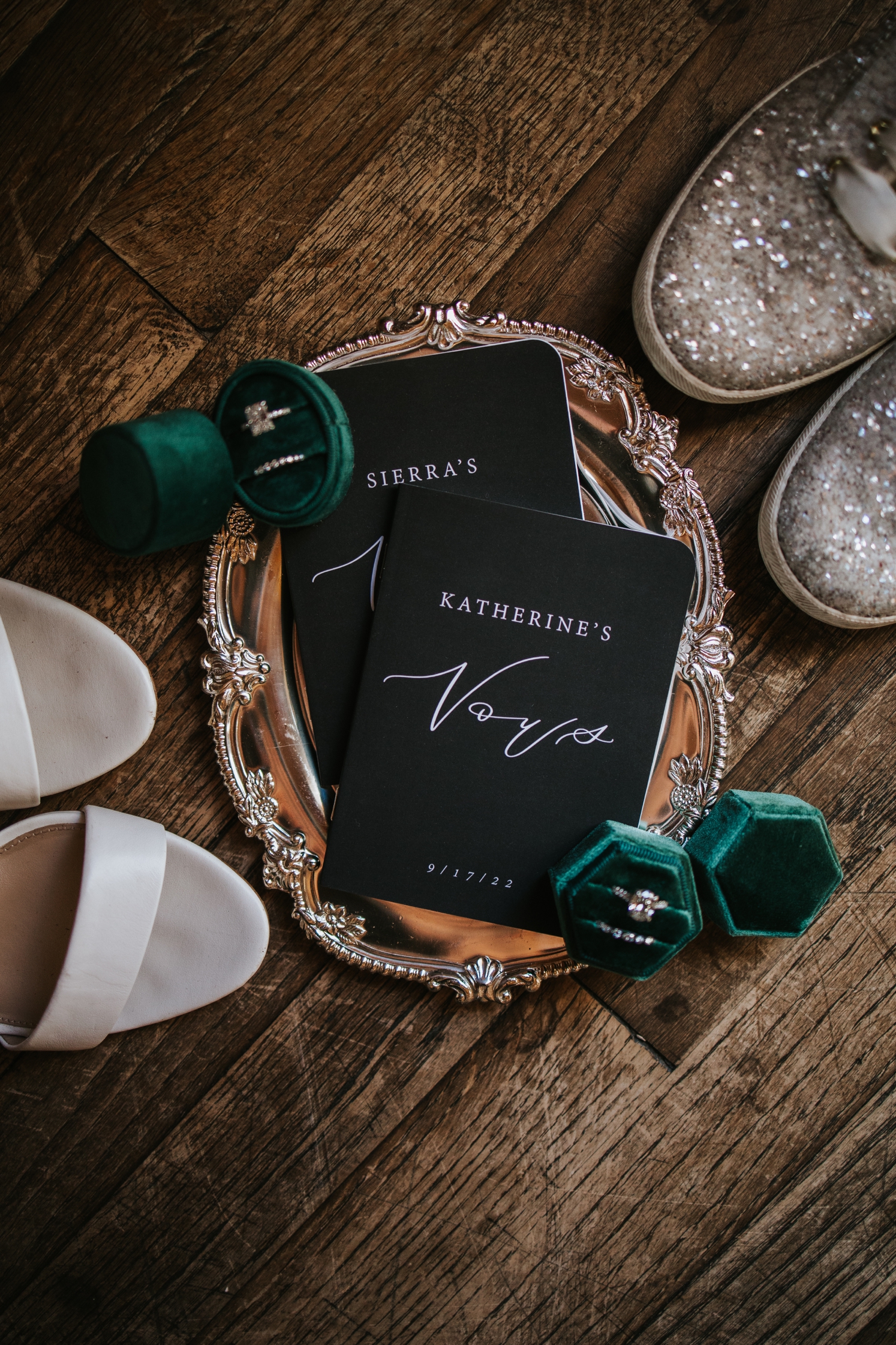 Black vow books with green velvet ring boxes on top of silver platter | McArthur Weddings and Events