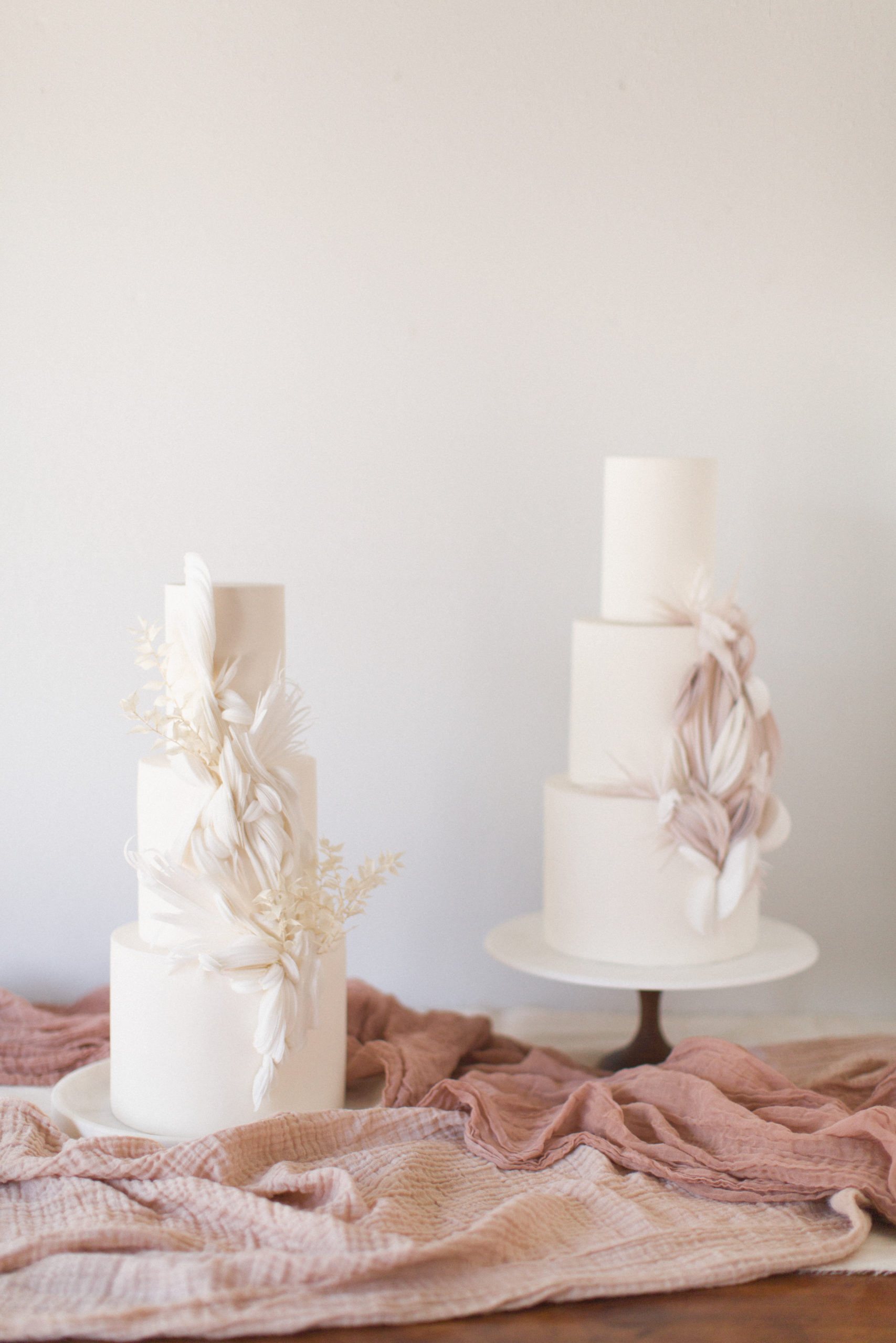Two three tier white wedding cakes with floral details | McArthur Weddings and Events