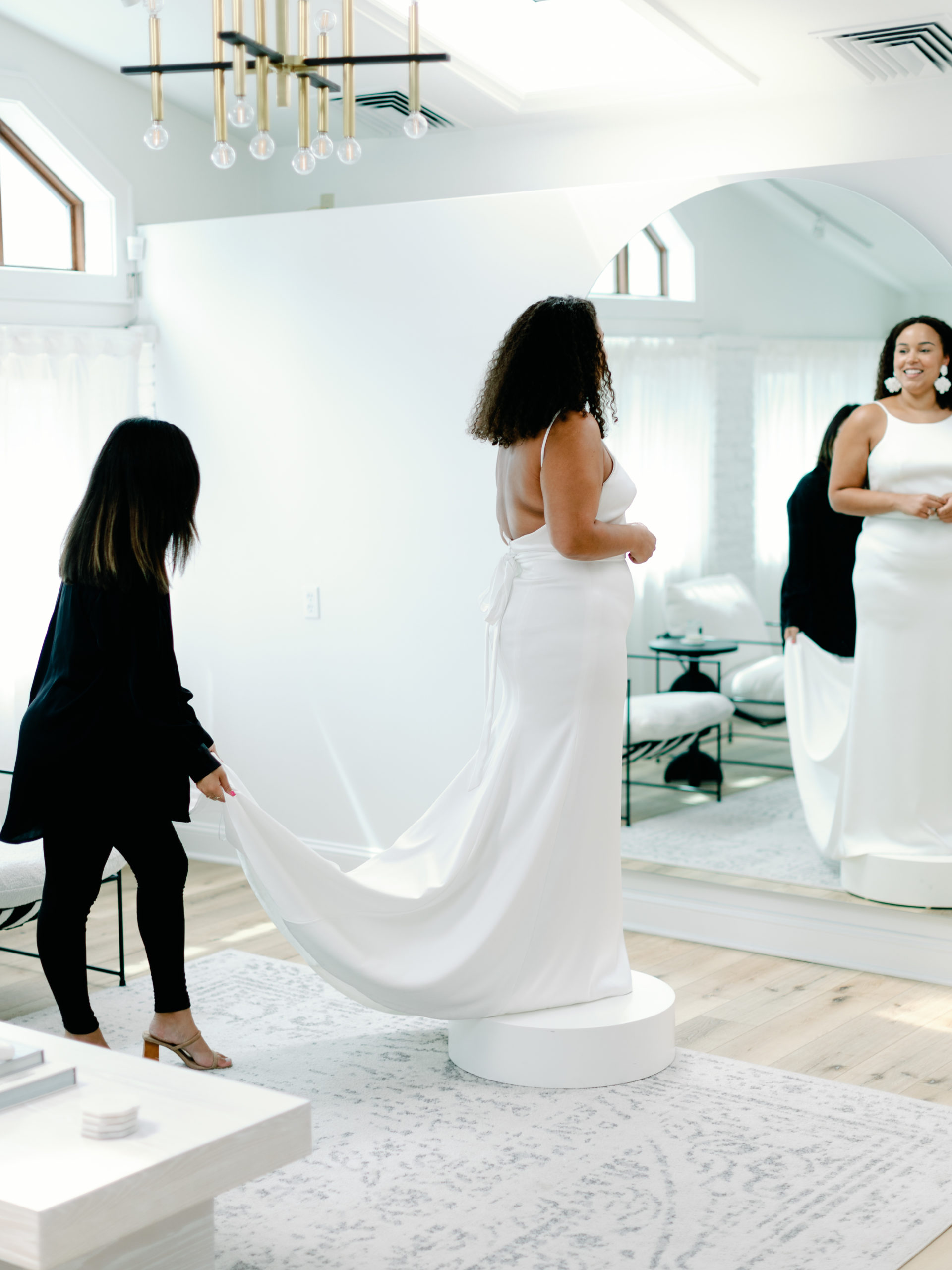 Bride trying on wedding dress at bridal shop | McArthur Weddings and Events