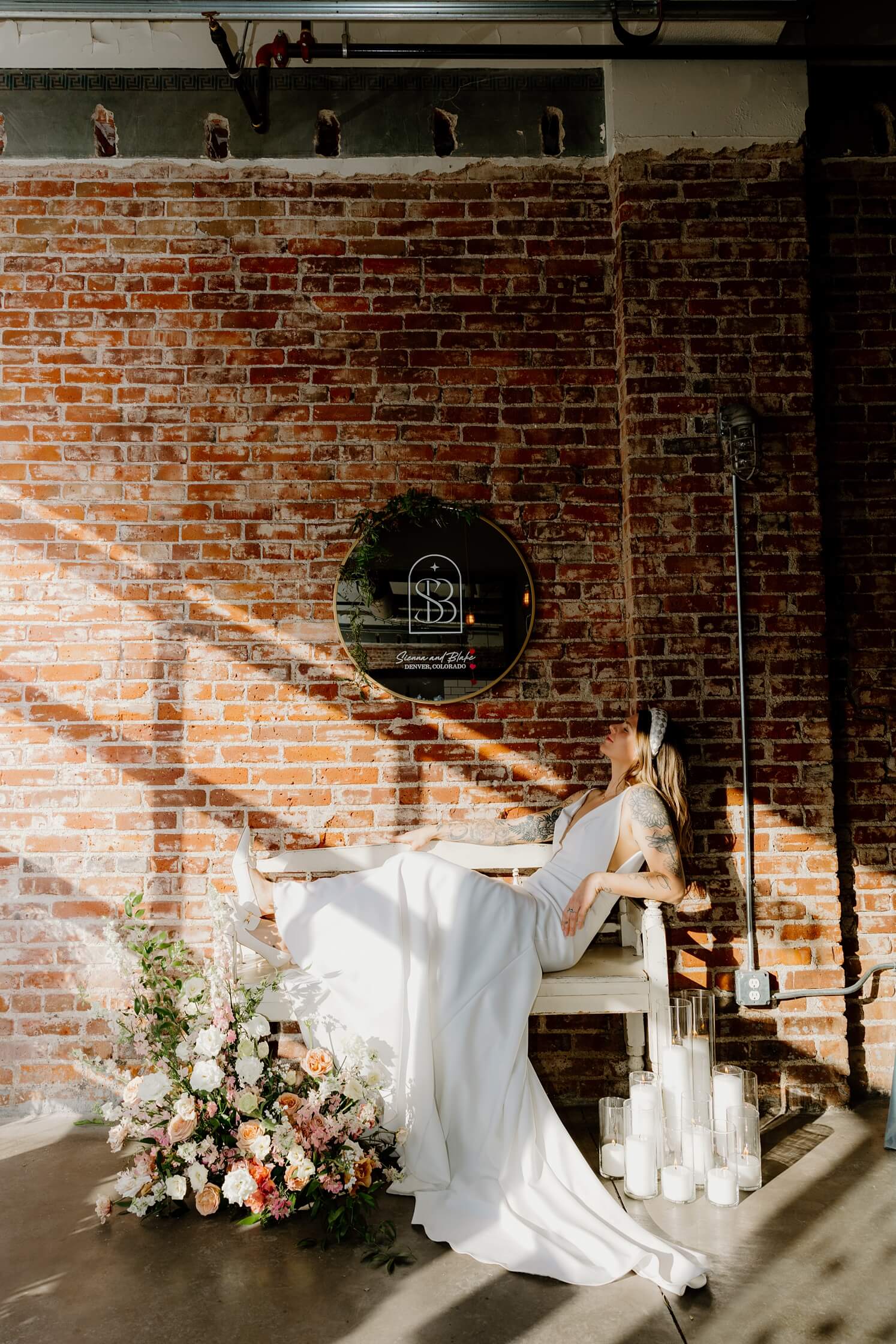 Bride sitting on bench underneath mirror sign by McArthur Weddings and Events | McArthur Weddings and Events