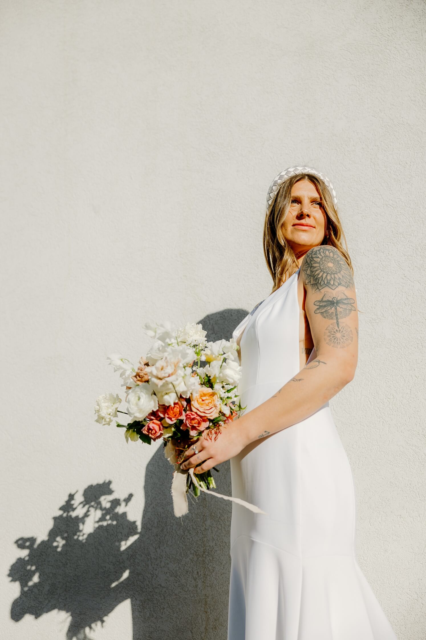 Bride looking off into the distance holding bouquet | McArthur Weddings and Events