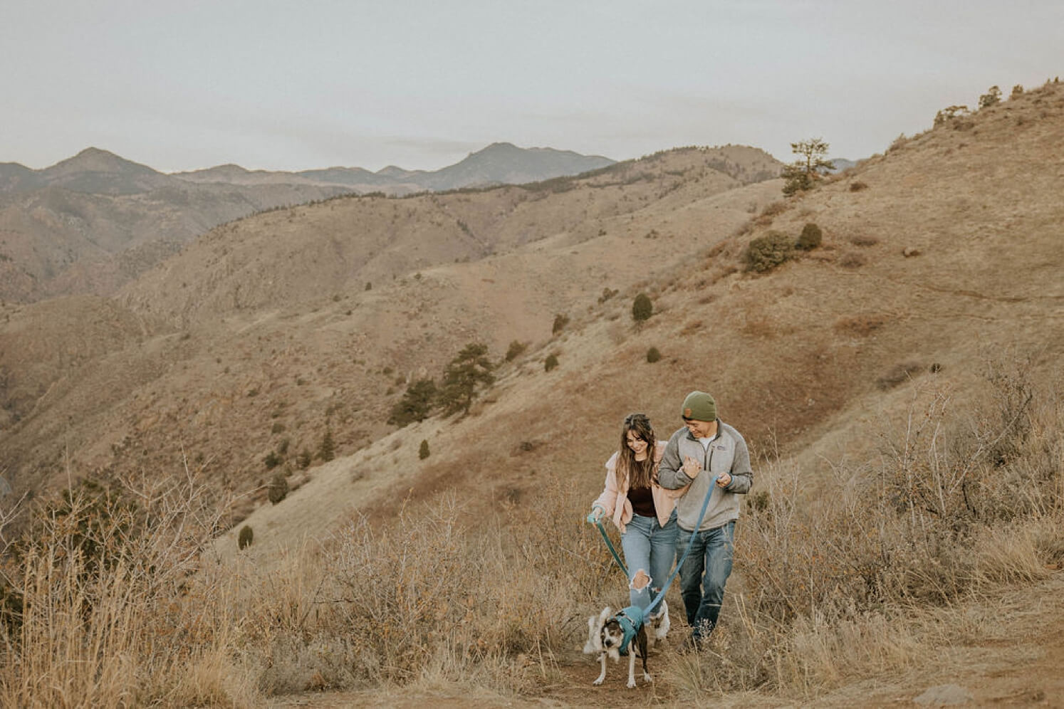 Couple walking with dogs in Colorado before elopement | McArthur Weddings and Events