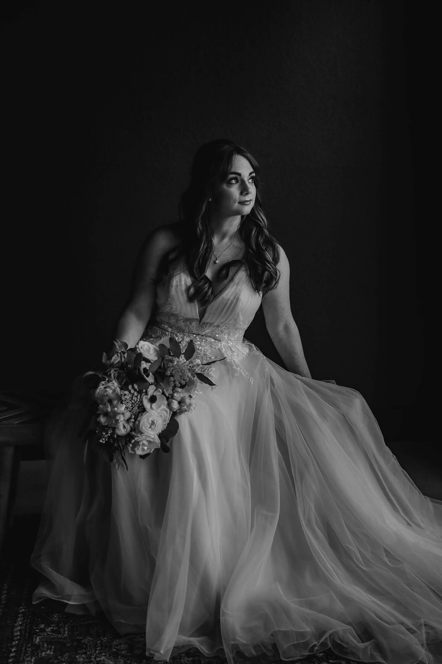 Bride sitting down in dress looking off in the distance before Colorado elopement | McArthur Weddings and Events