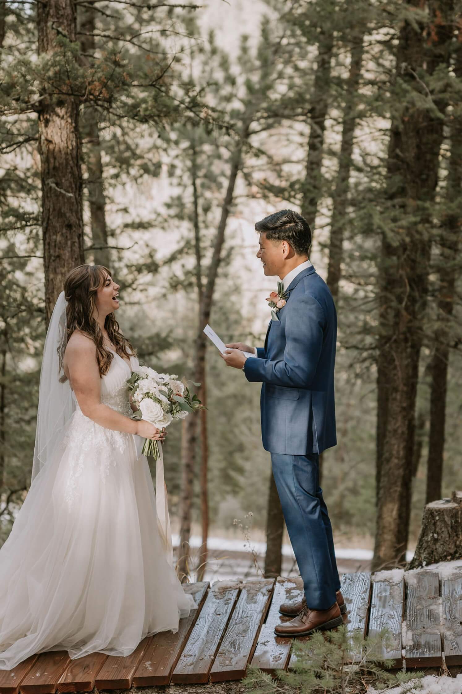 Groom reading vows to bride while they laugh during Colorado elopement at Juniper Mountain House | McArthur Weddings and Events