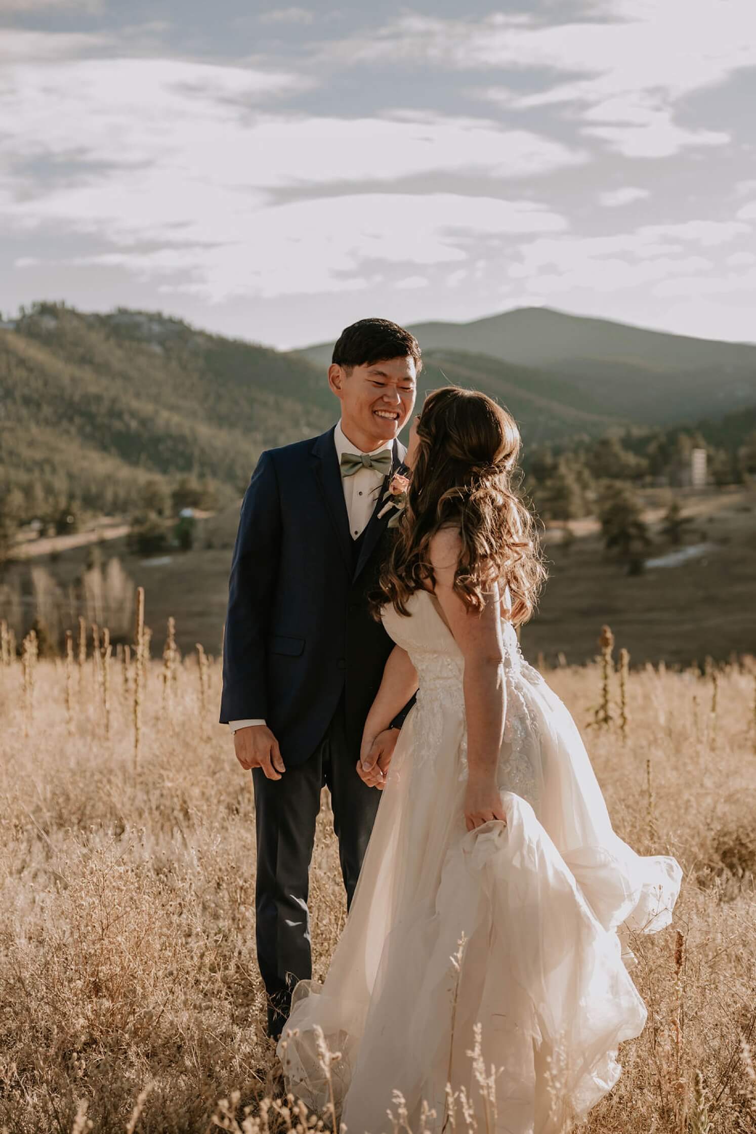 Bride and groom laughing and looking at each other outdoors after Colorado elopement | McArthur Weddings and Events