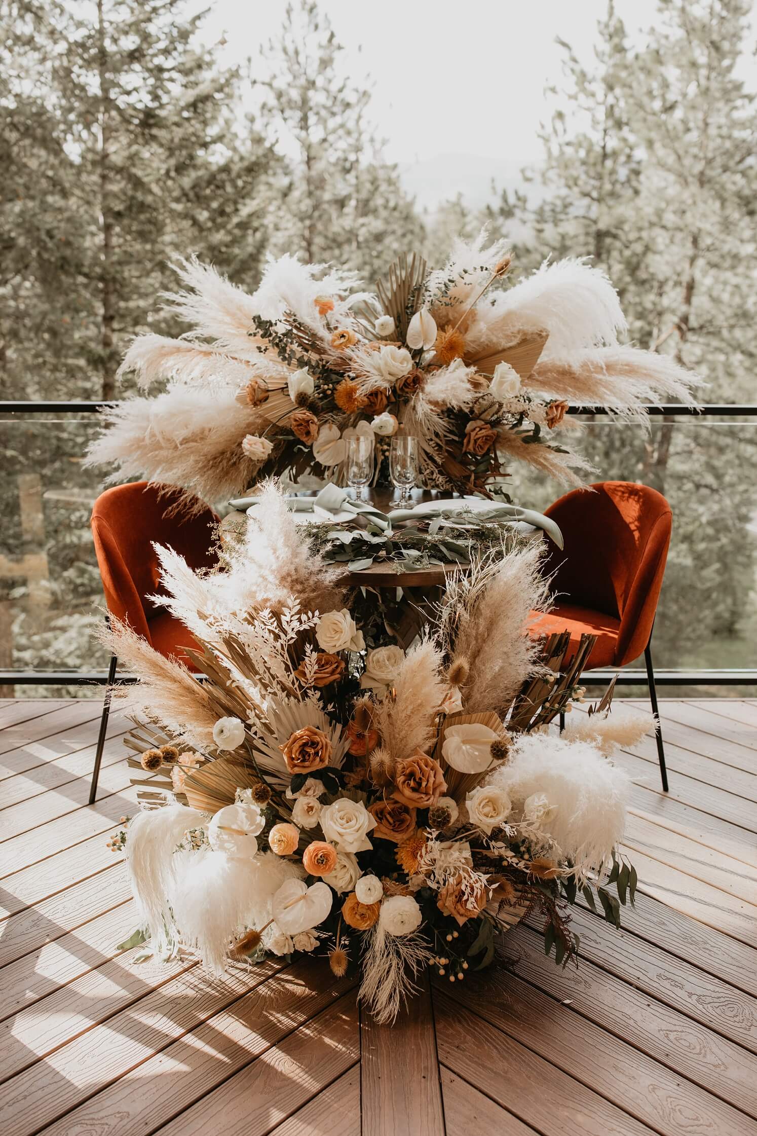 Wedding floral design: sweetheart table with boho wedding florals in front of and behind the table | McArthur Weddings and Events