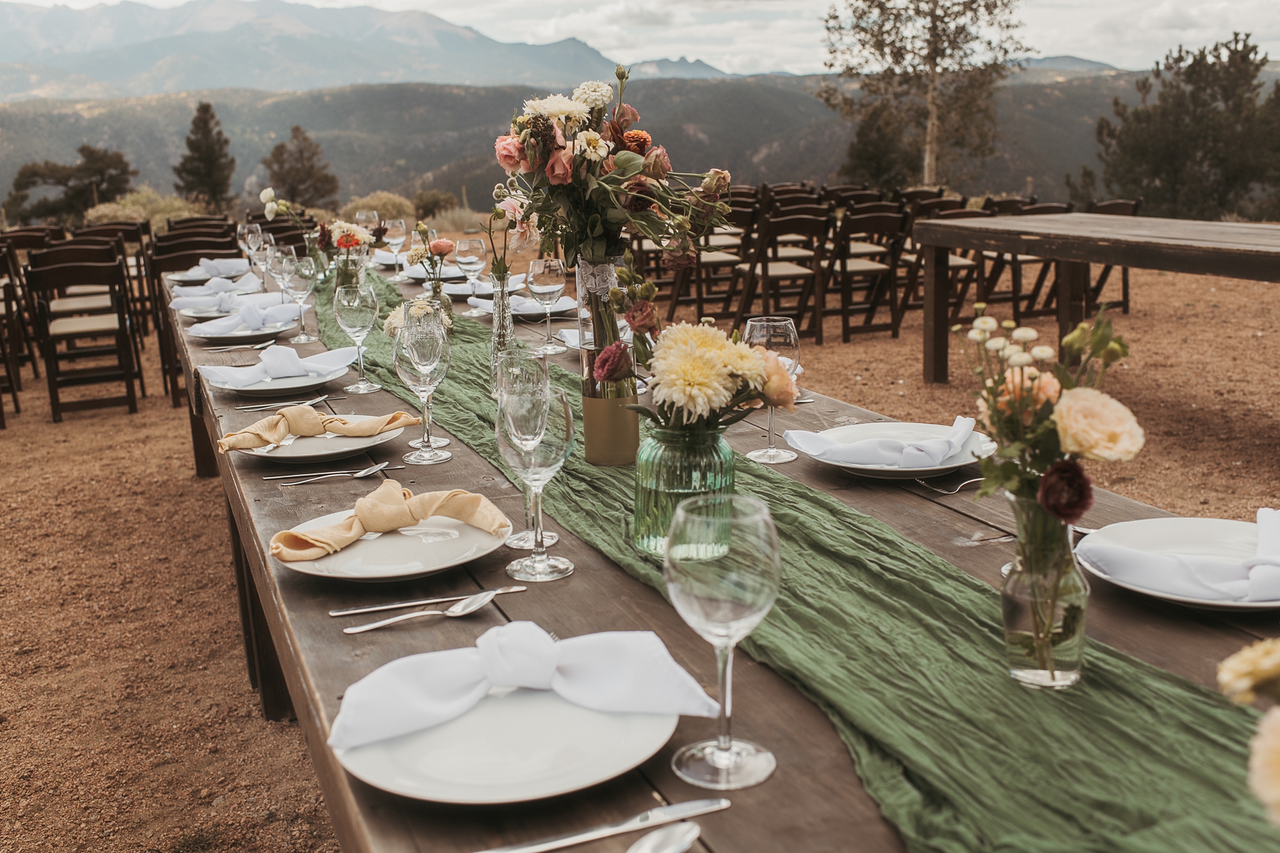 Farmhouse table with assorted pink and white flowers at Airbnb wedding venue in Colorado