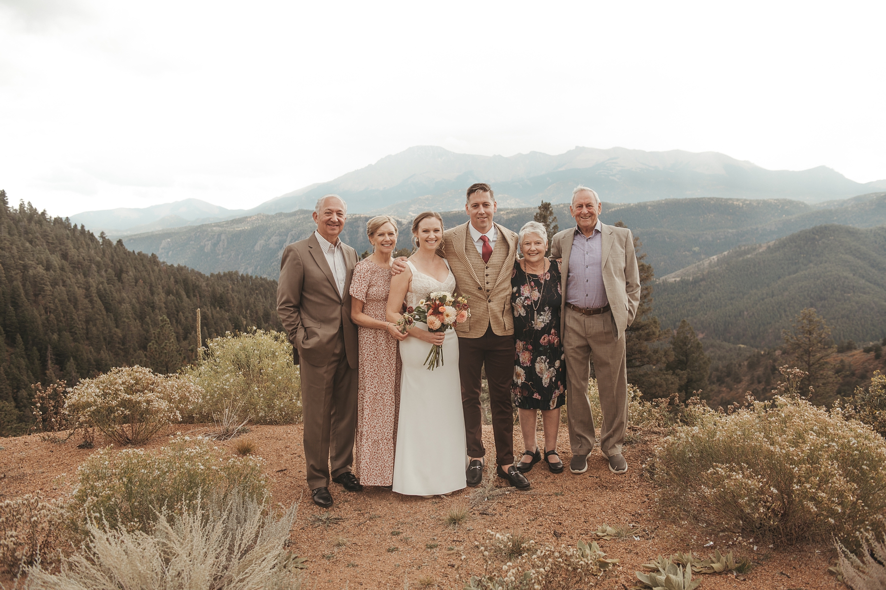 Bride and groom with family in front of mountains at Airbnb wedding venue in Colorado