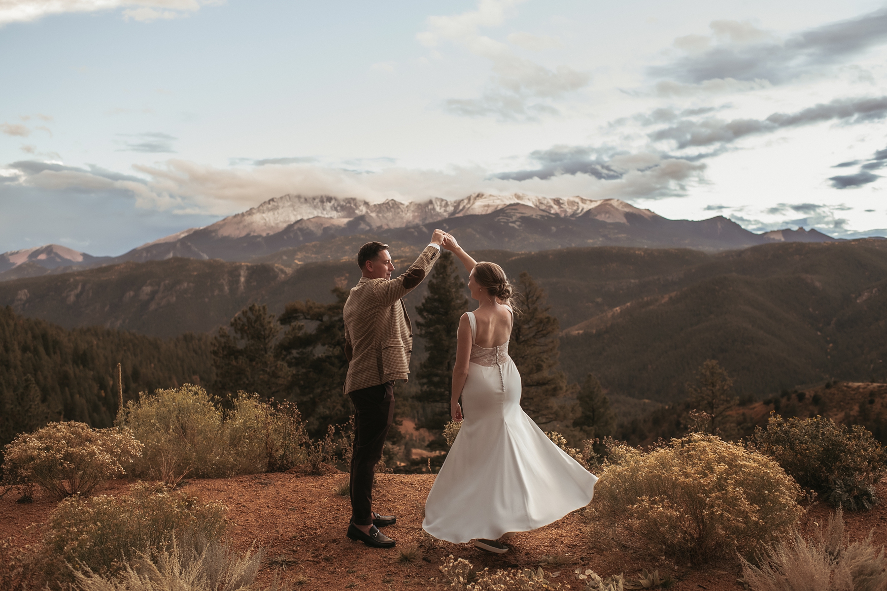 Groom twirling bride in front of mountains at Airbnb wedding venue in Colorado