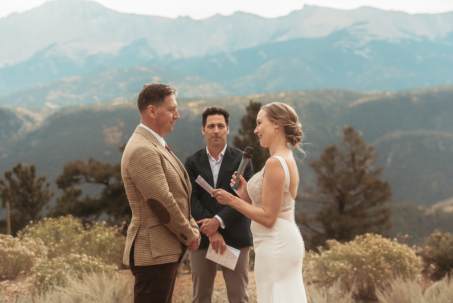 Bride saying vows to groom in front of mountains 