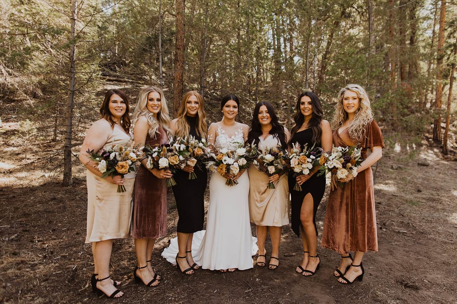 Bride with bridesmaids in shades of brown at Evergreen wedding venue | McArthur Weddings and Events