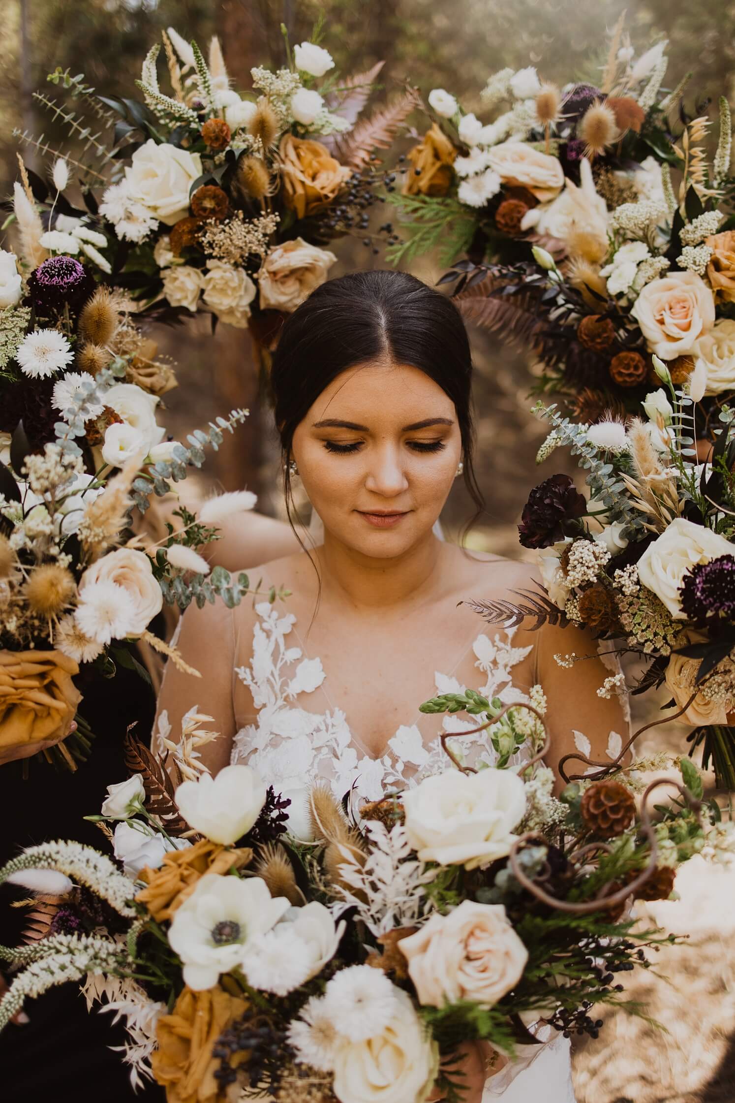 Bride in floral halo created by bridesmaids bouquet | McArthur Weddings and Events