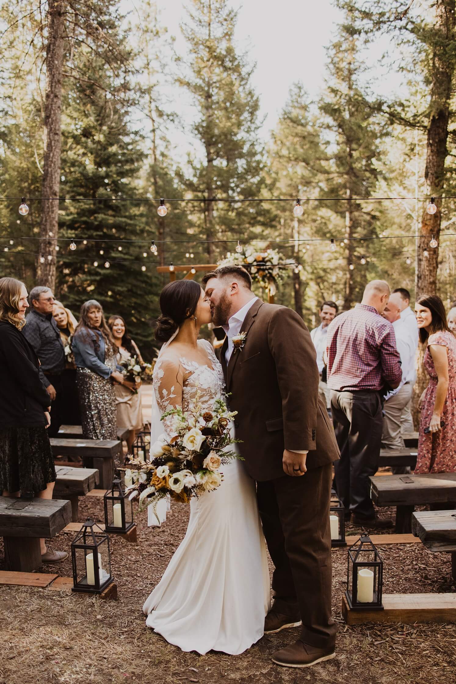 bride and groom kissing as they walk down the aisle at Evergreen wedding venue | McArthur Weddings and Events