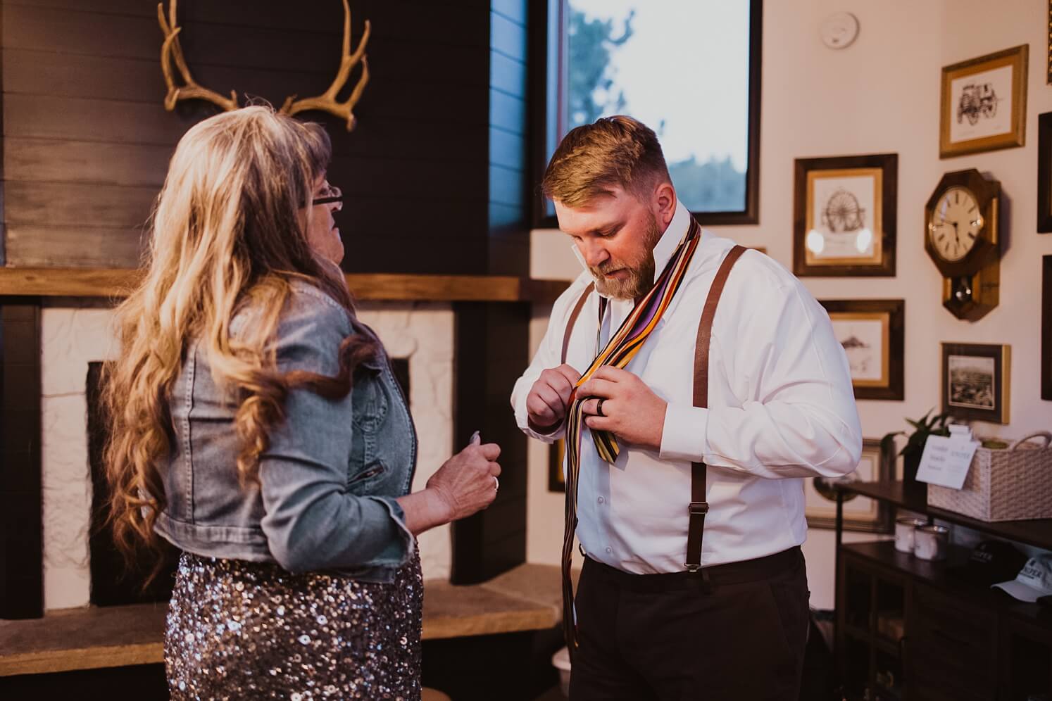 Groom putting on brother's tie during reception | McArthur Weddings and Events