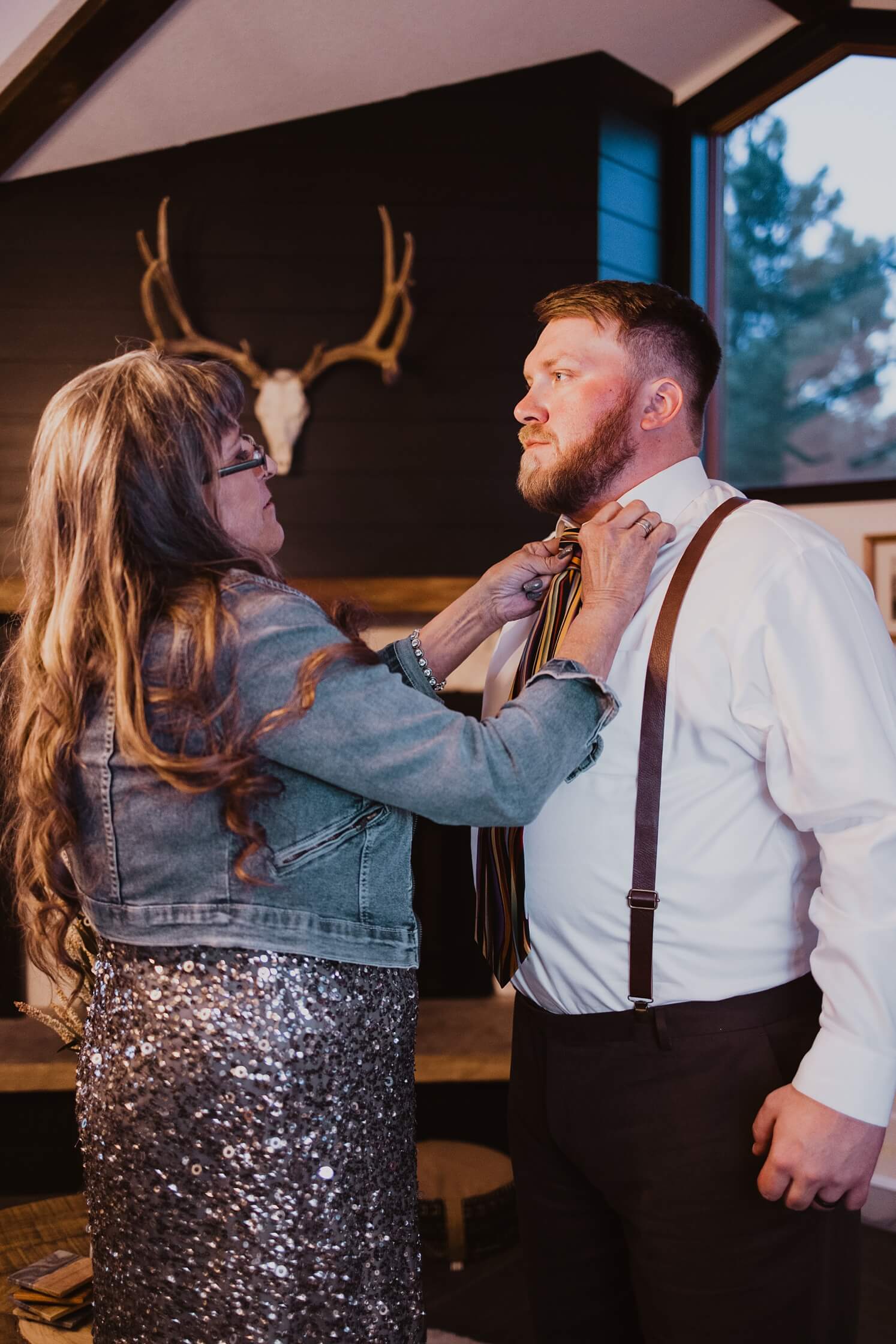 Mom helping son put on tie at wedding reception | McArthur Weddings and Events