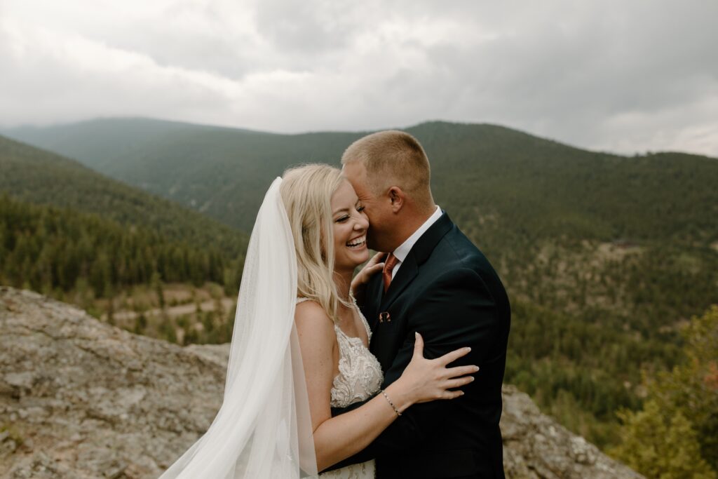 Bride smiling while she hugs husband at Idaho Springs wedding venue | McArthur Weddings and Events