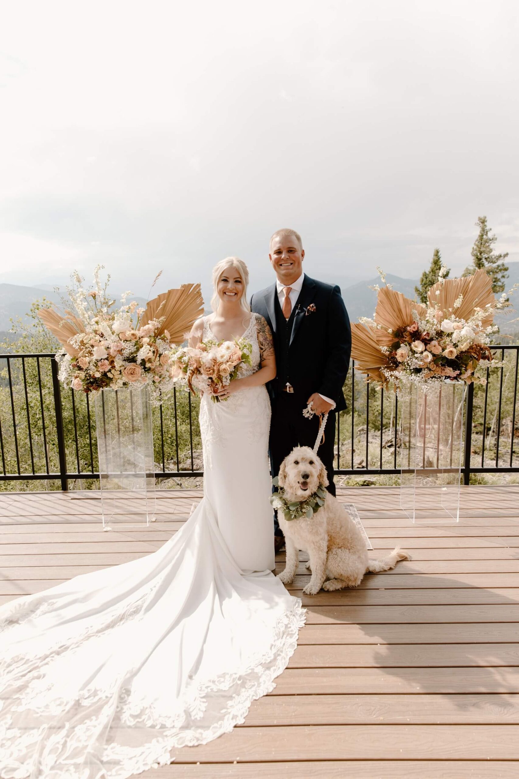Bride and groom with dog on deck of idaho springs wedding venue after ceremony | McArthur Weddings and Events