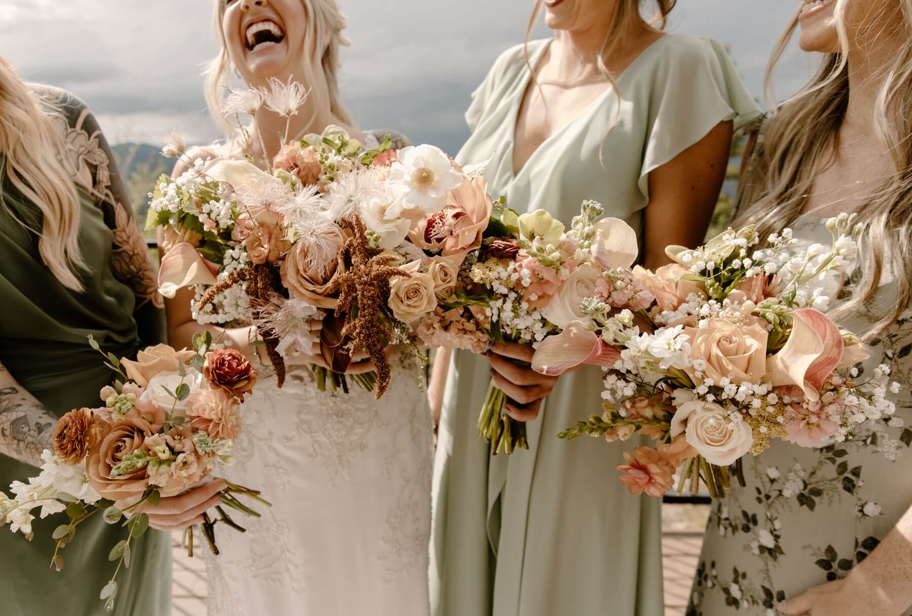 Bride and bridesmaids' boho bouquets full of pink and white flowers at idaho springs wedding venue McArthur Weddings and Events