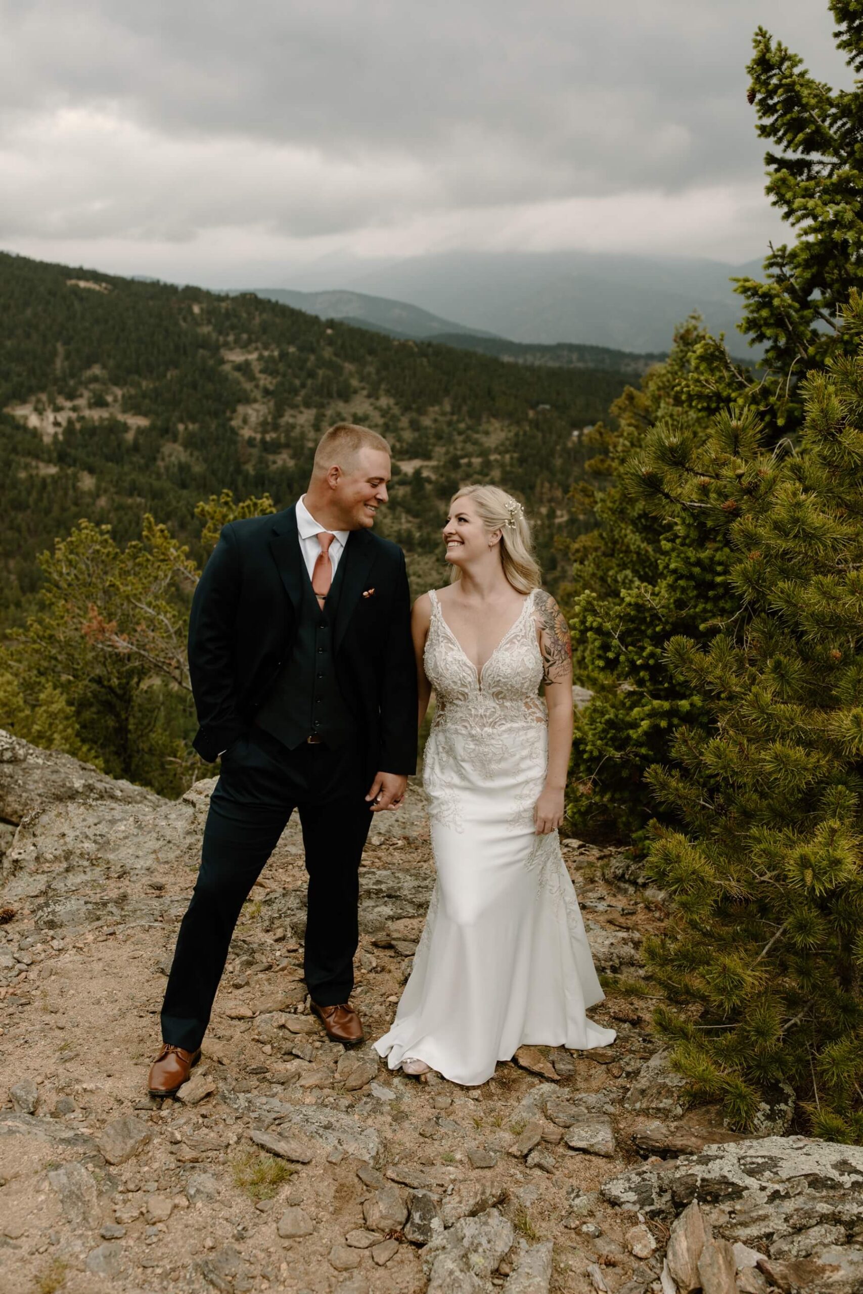 Bride and groom holding hands and looking at each other in front of mountains at North Star Gatherings | McArthur Weddings and Events