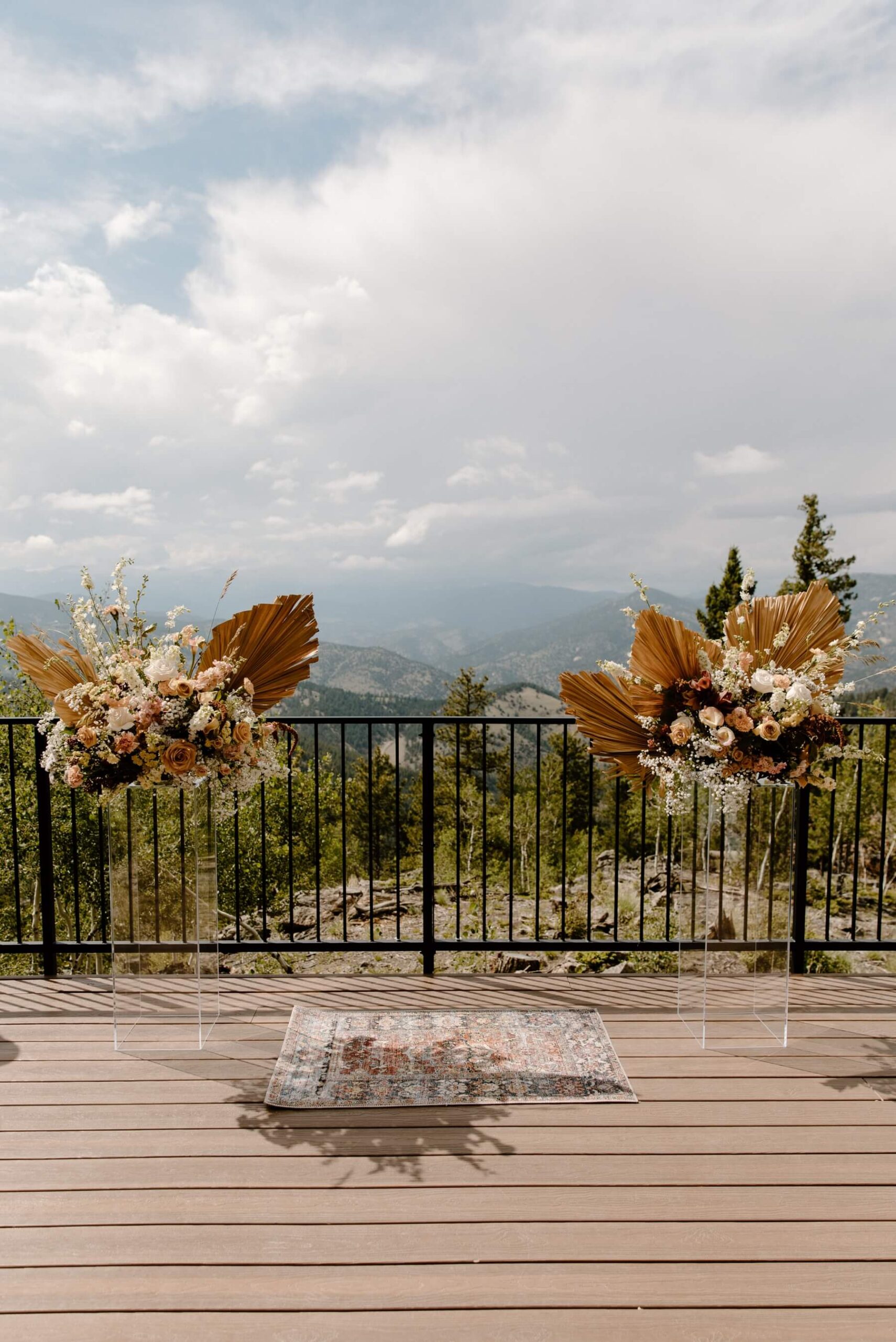 Boho floral arrangements on acrylic pillars at Idaho Springs wedding venue | McArthur Weddings and Events