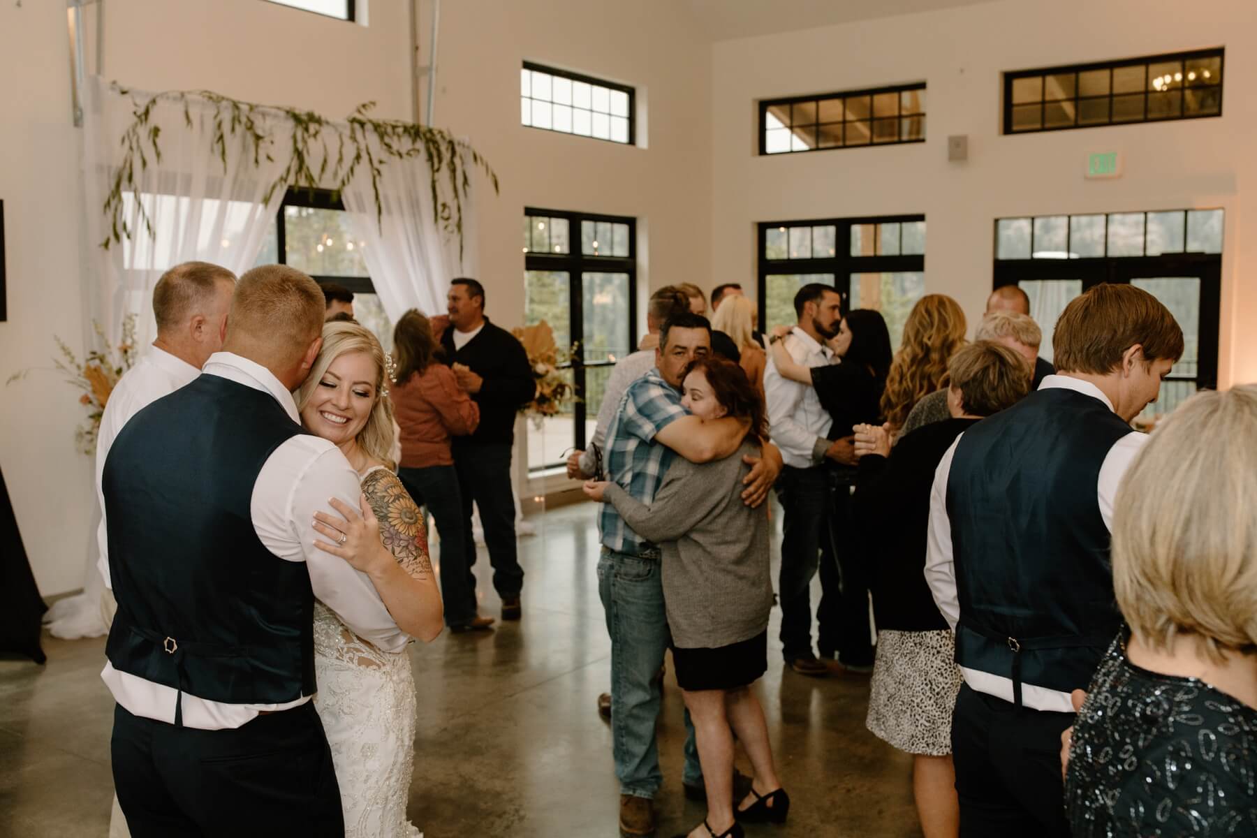 Bride and groom dancing with wedding guests at Idaho Springs wedding venue | McArthur Weddings and Events
