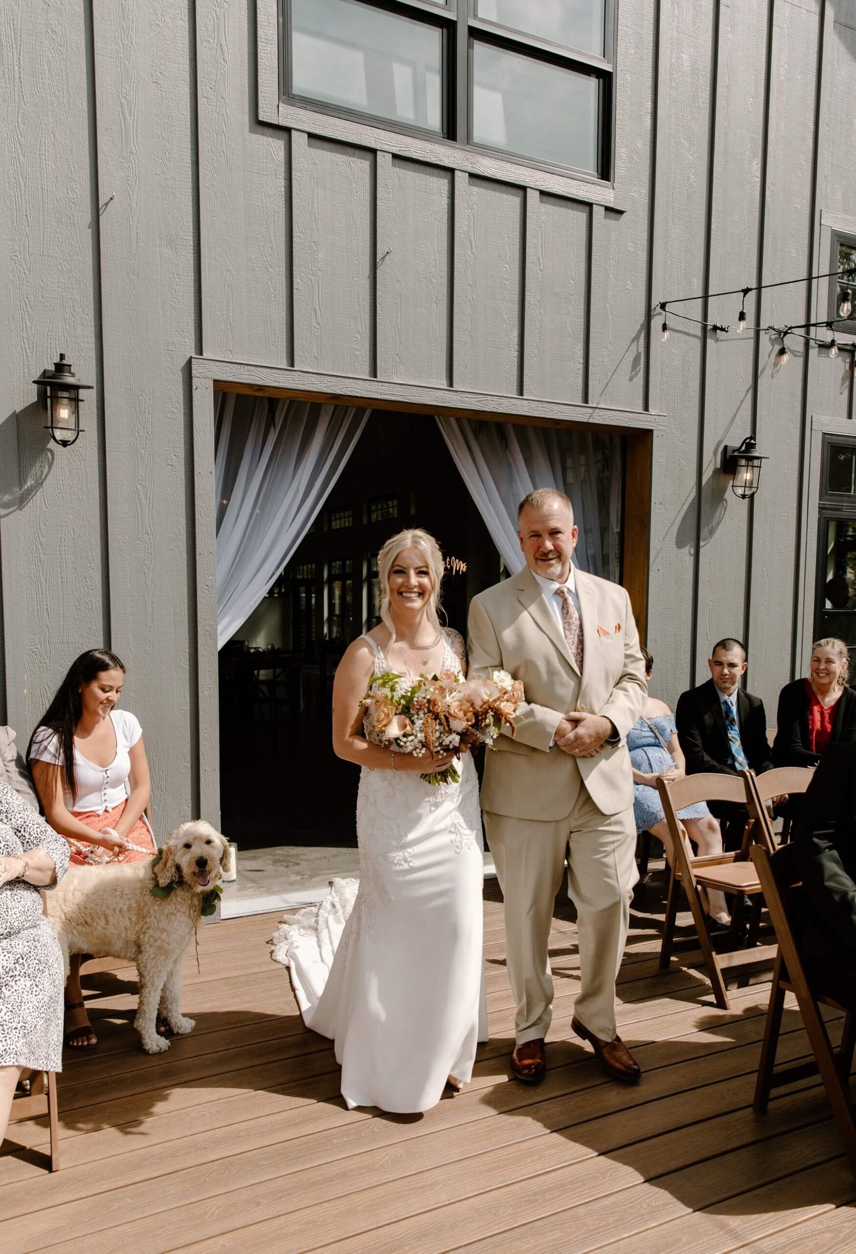 Bride walking down the aisle with father while her dog looks on | McArthur Weddings and Events