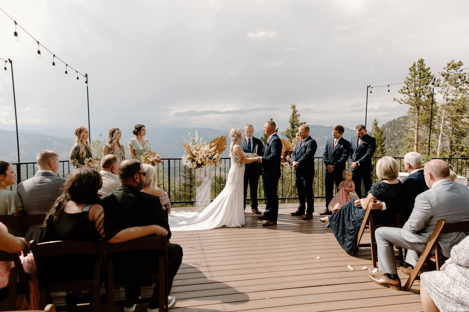 Bride and groom holding hands during wedding ceremony on deck at North Star Gatherings | McArthur Weddings and Events