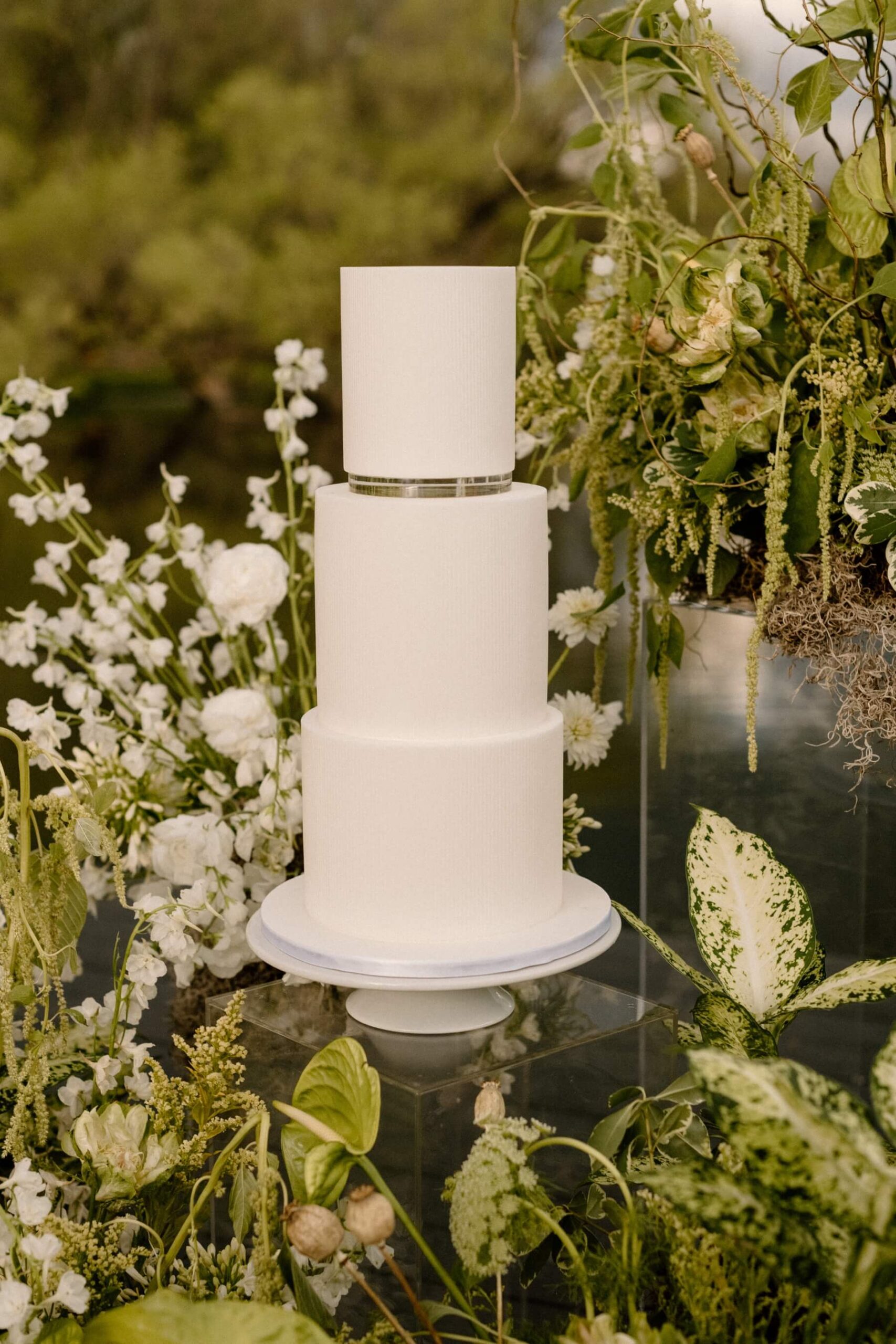 Three tier white wedding cake with silver band